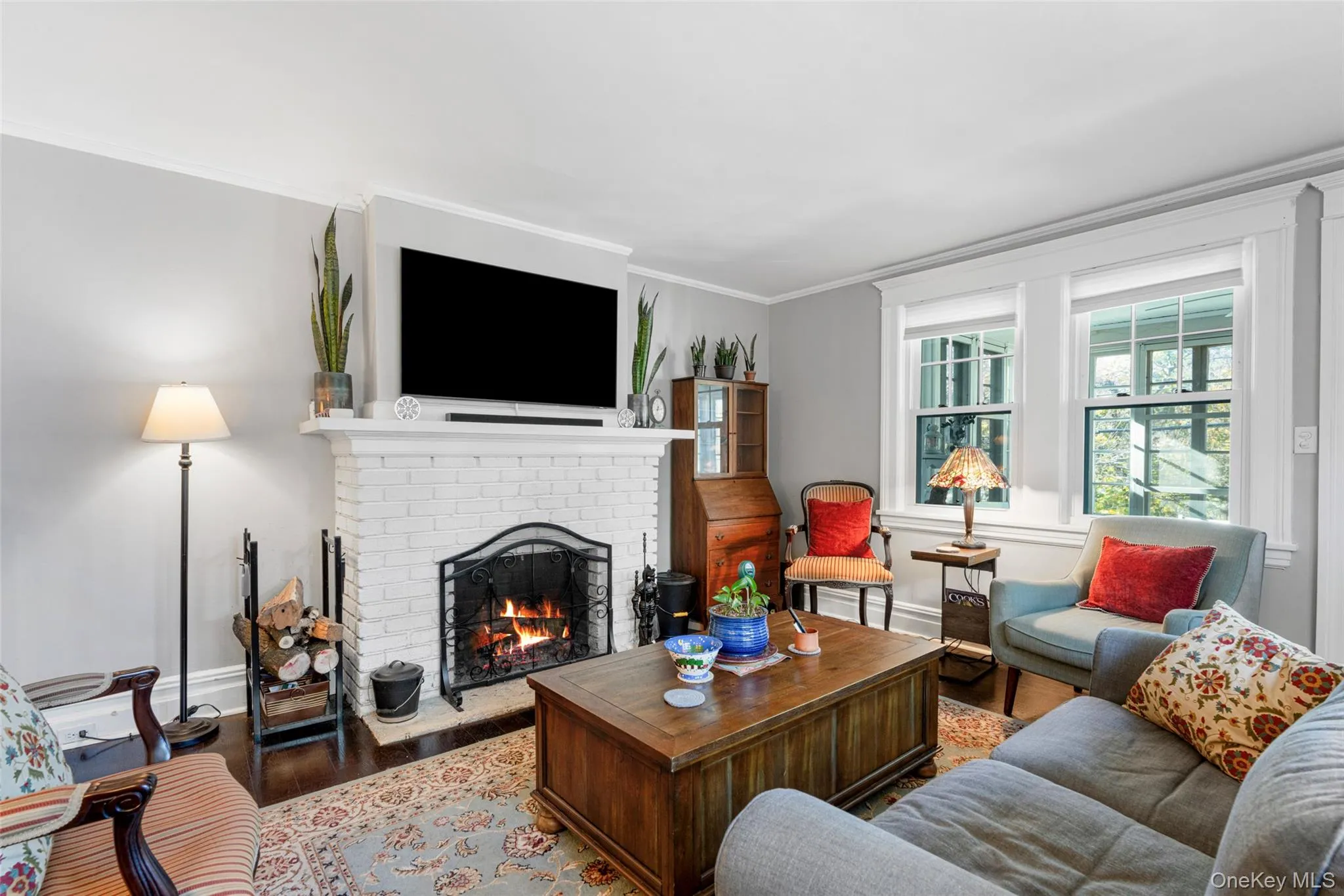 Living room featuring a fireplace, hardwood / wood-style flooring, and crown molding Living room featuring a fireplace, hardwood / wood-style flooring, and crown molding