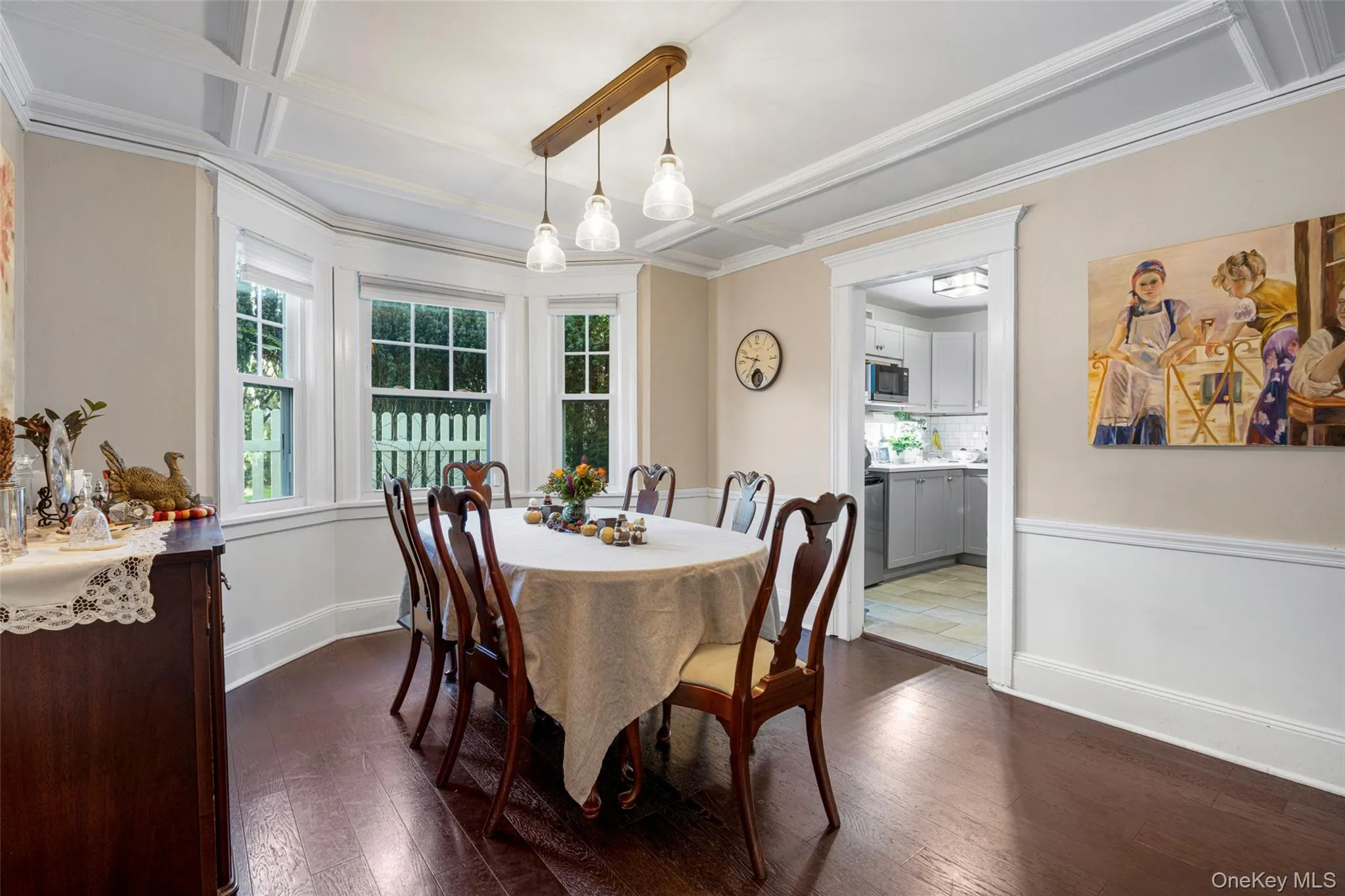 Dining room with dark wood-type flooring, beam ceiling, crown molding, and coffered ceiling Dining room with dark wood-type flooring, beam ceiling, crown molding, and coffered ceiling