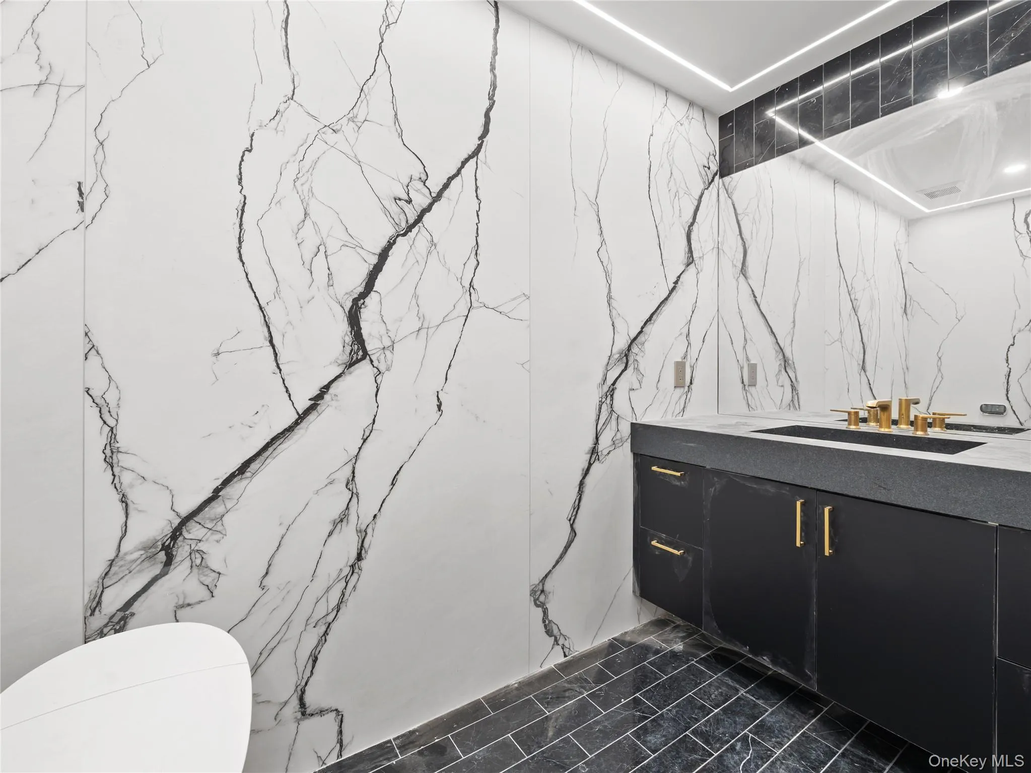 Bathroom featuring stone wall, vanity, and tile walls Bathroom featuring stone wall, vanity, and tile walls