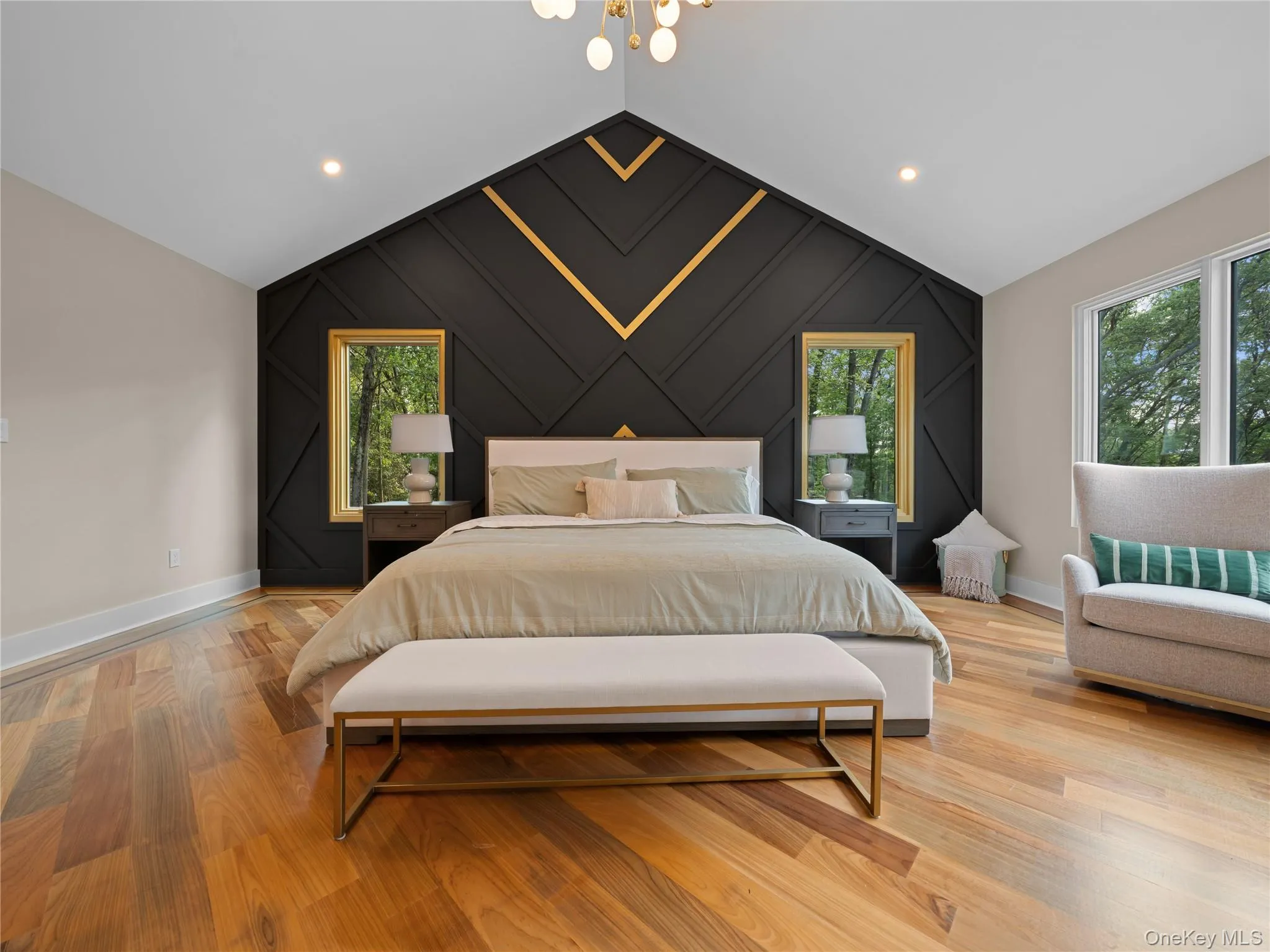 Bedroom featuring light wood finished floors, an accent wall, lofted ceiling, recessed lighting, and a chandelier Bedroom featuring light wood finished floors, an accent wall, lofted ceiling, recessed lighting, and a chandelier
