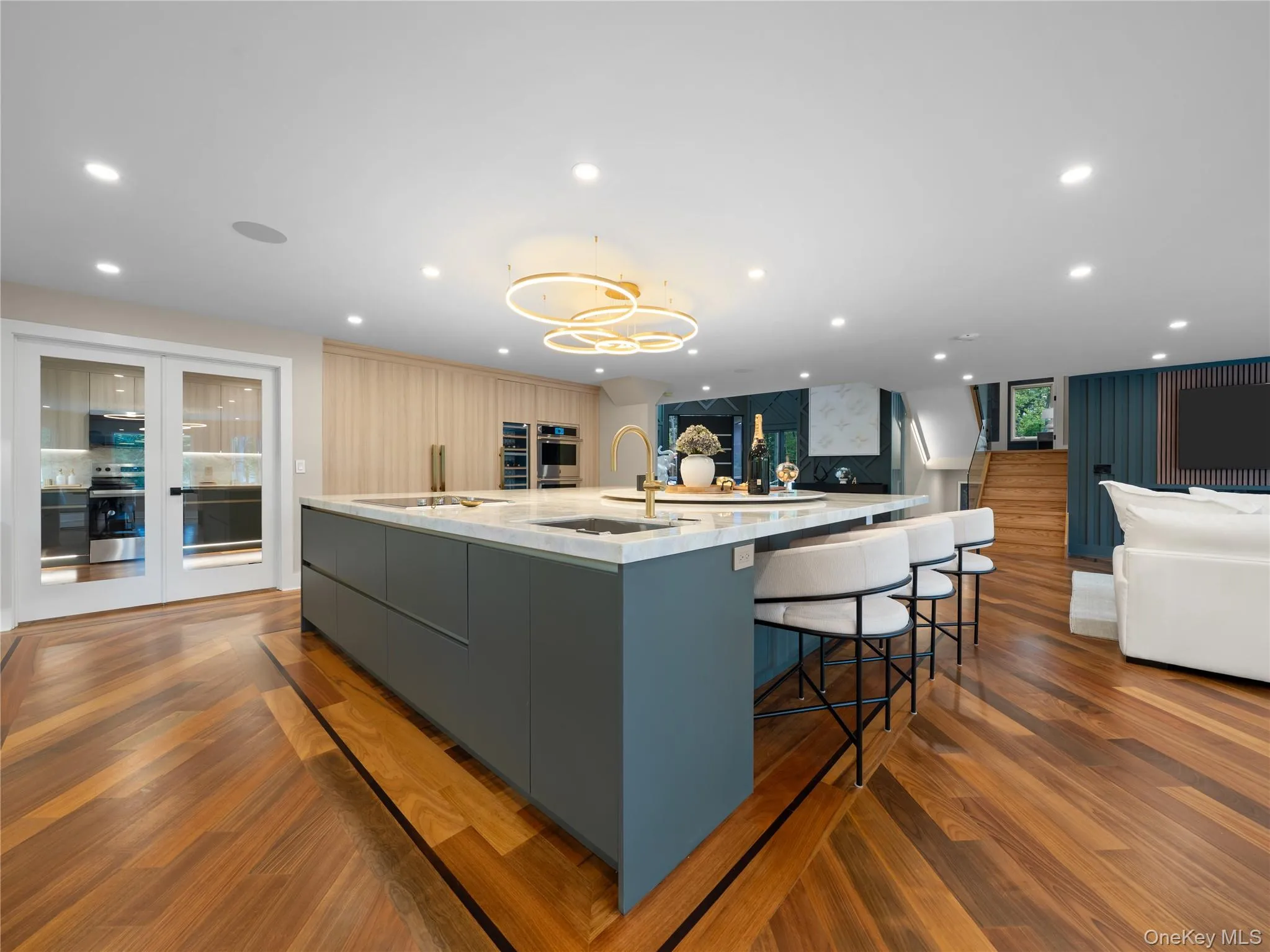 Kitchen featuring modern cabinets, recessed lighting, dark wood finished floors, a large island with sink, and gray cabinets Kitchen featuring modern cabinets, recessed lighting, dark wood finished floors, a large island with sink, and gray cabinets