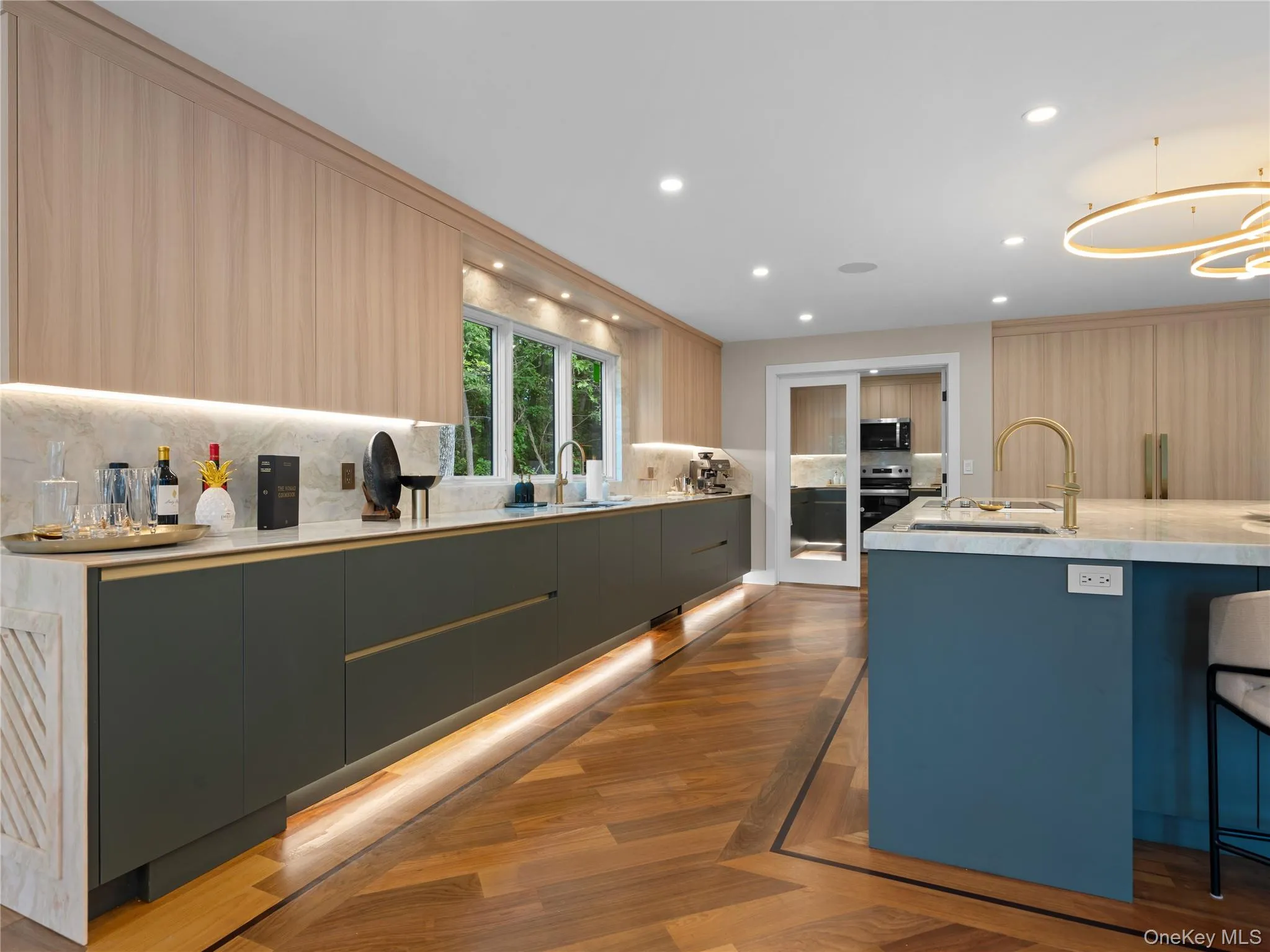 Kitchen featuring modern cabinets, light stone counters, backsplash, and recessed lighting Kitchen featuring modern cabinets, light stone counters, backsplash, and recessed lighting