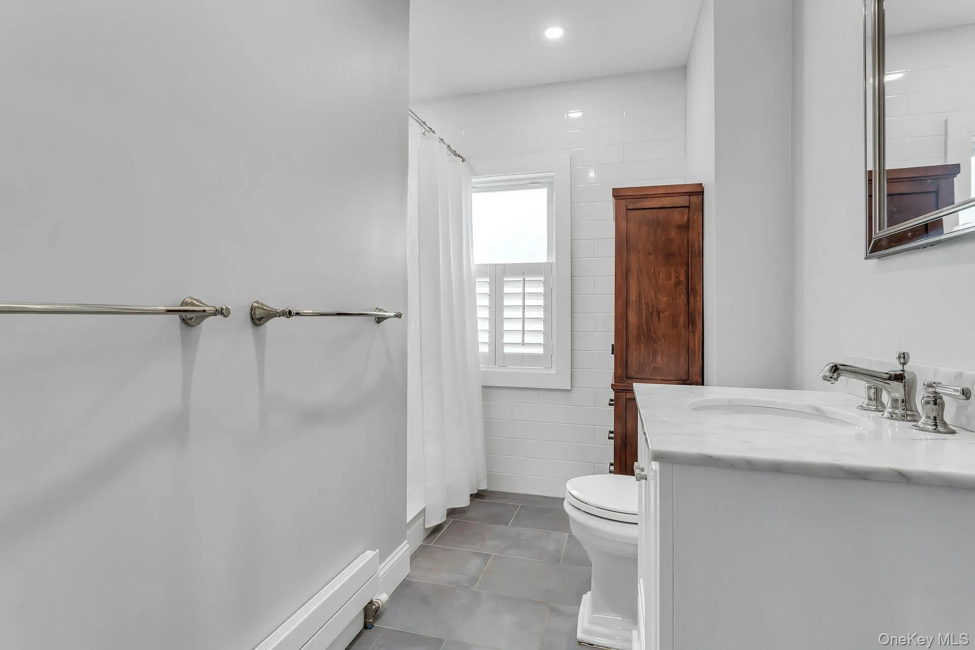 White vanity with a stone countertop and polished chrome fixtures White vanity with a stone countertop and polished chrome fixtures