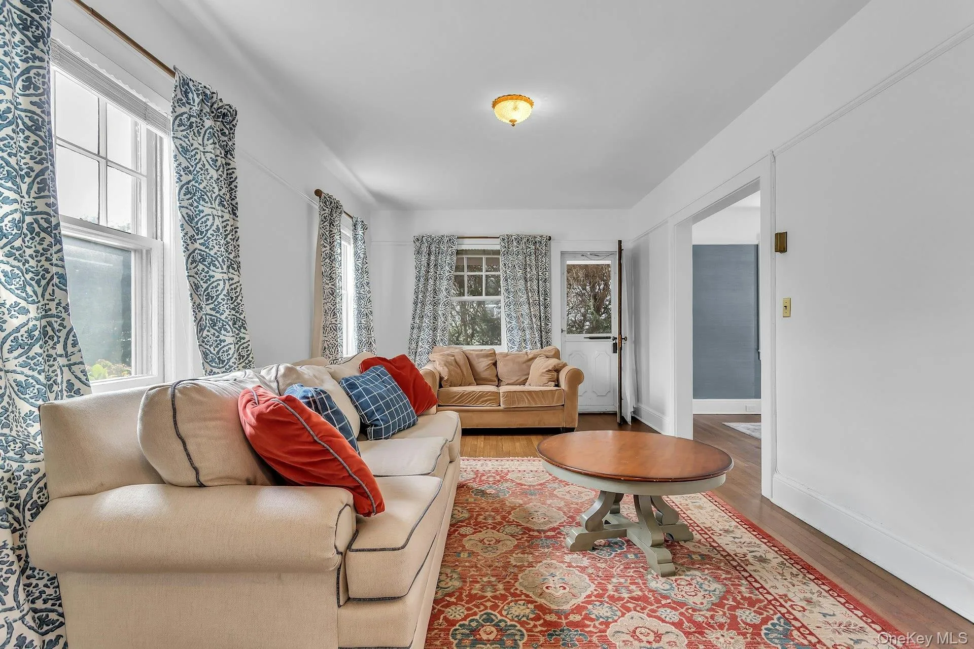Hardwood flooring, painted white walls, recessed doorway, and a ceiling-mounted light fixture Hardwood flooring, painted white walls, recessed doorway, and a ceiling-mounted light fixture