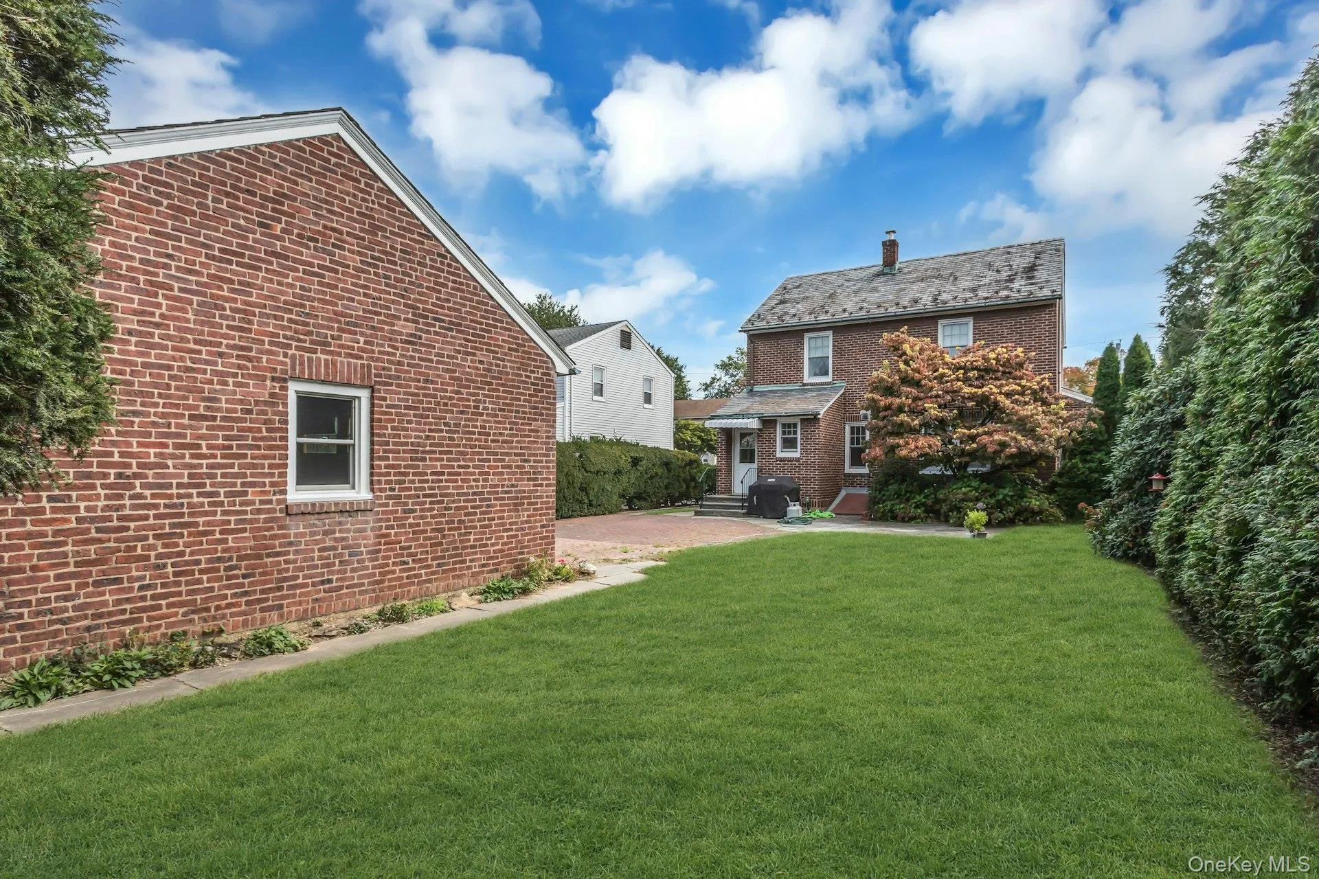 Expansive lawn, brick exterior, paved patio, and mature perimeter landscaping Expansive lawn, brick exterior, paved patio, and mature perimeter landscaping