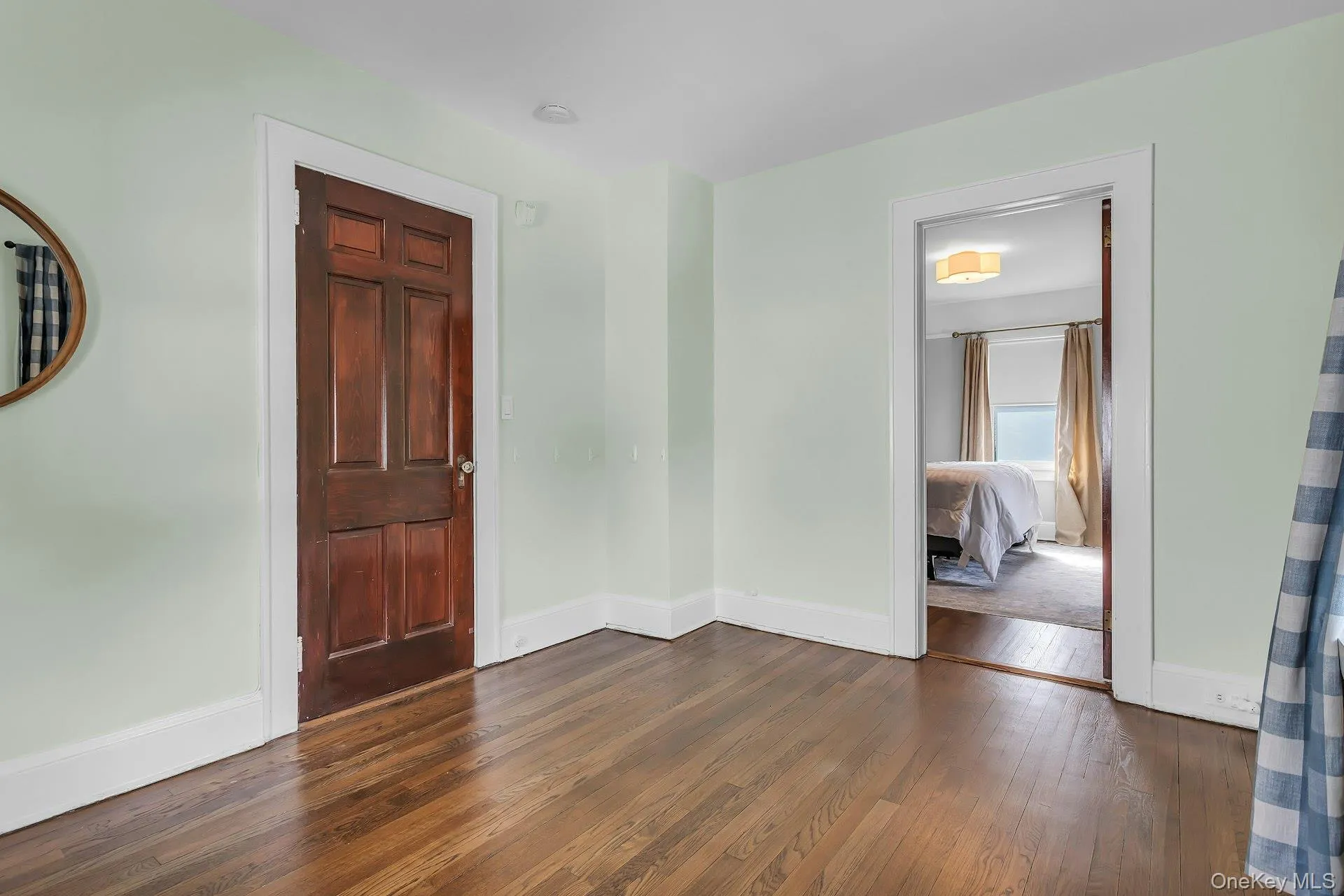 Hardwood flooring, painted walls, solid panel interior door, and a cased opening Hardwood flooring, painted walls, solid panel interior door, and a cased opening