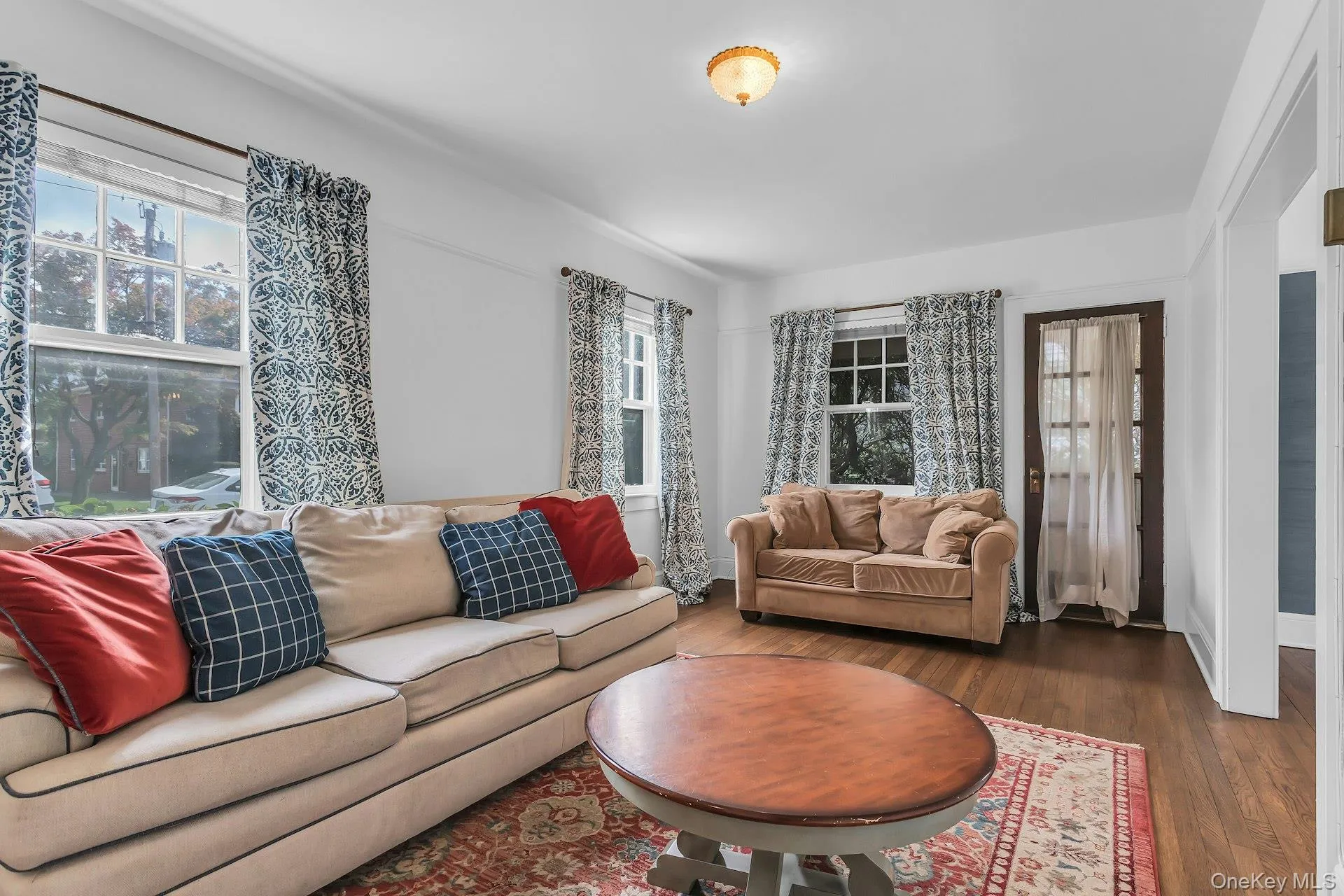 Hardwood flooring, multiple windows providing natural light, white wall finishes, and a classic ceiling fixture Hardwood flooring, multiple windows providing natural light, white wall finishes, and a classic ceiling fixture