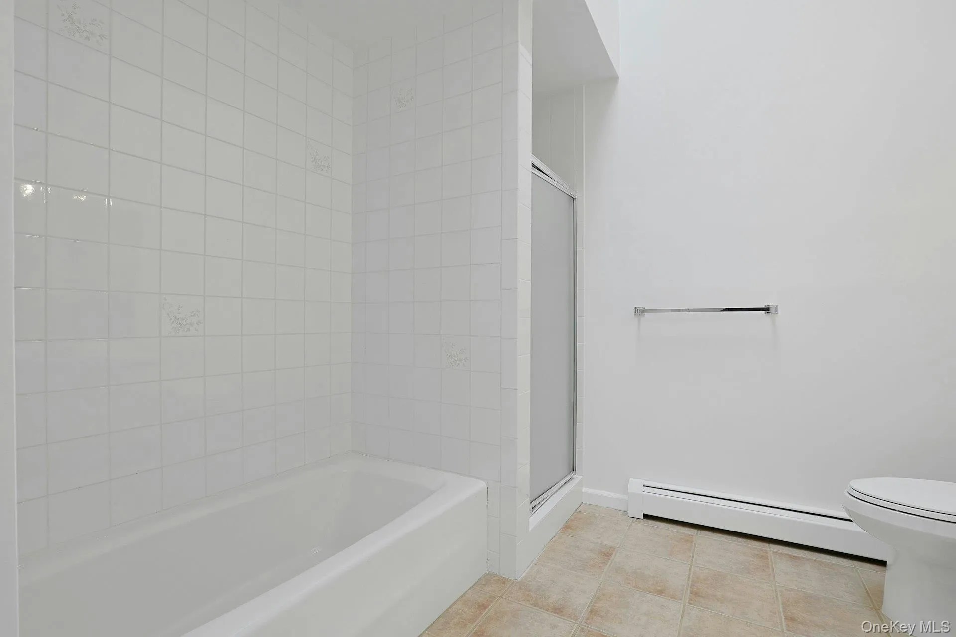 With both a tiled bathtub and a separate glass shower, the bathroom offers many options. With both a tiled bathtub and a separate glass shower, the bathroom offers many options.
