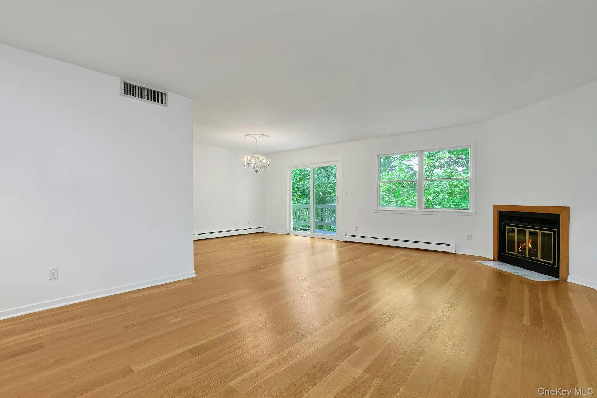 The expansive living room has bright, wood floors that shine from the natural light that flows in from the large windows and sliding doors to the deck. There is plenty of space here for multiple seating areas, and abundant wall space for your art collection. The expansive living room has bright, wood floors that shine from the natural light that flows in from the large windows and sliding doors to the deck. There is plenty of space here for multiple seating areas, and abundant wall space for your art collection.