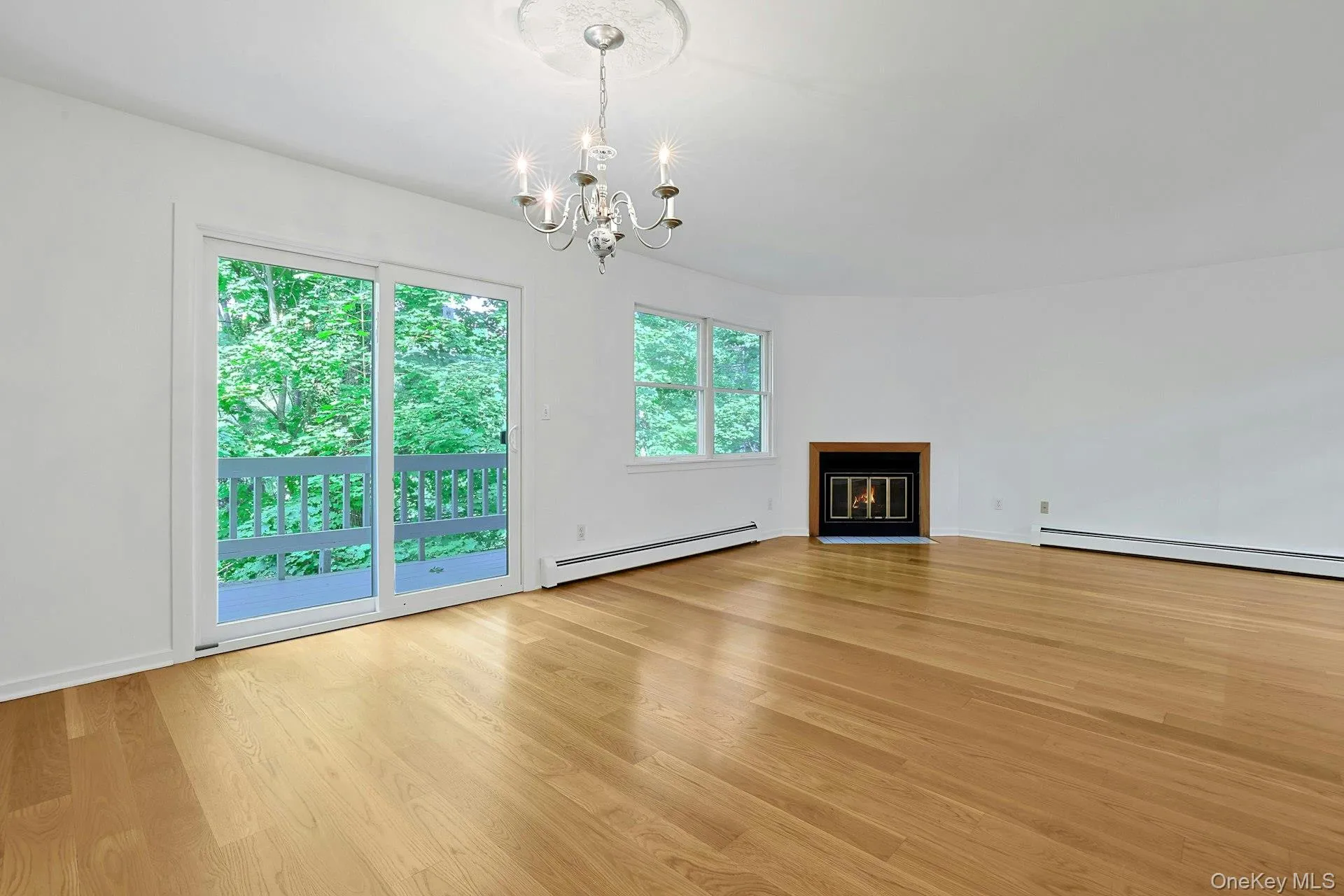 Centered under an elegant chandelier with a rosette, the dining room has sliding doors out to the rear deck. Centered under an elegant chandelier with a rosette, the dining room has sliding doors out to the rear deck.