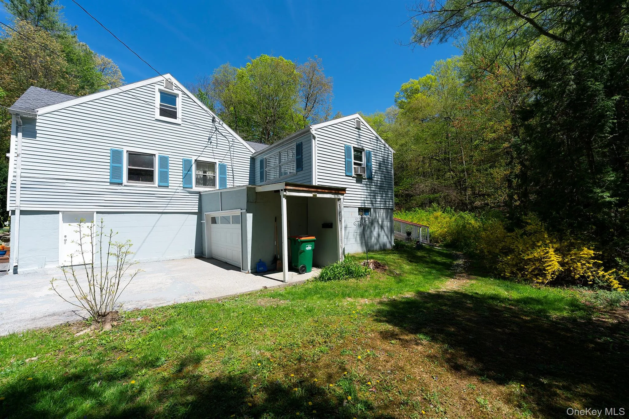 View of property exterior with a garage, concrete driveway, and a lawn View of property exterior with a garage, concrete driveway, and a lawn