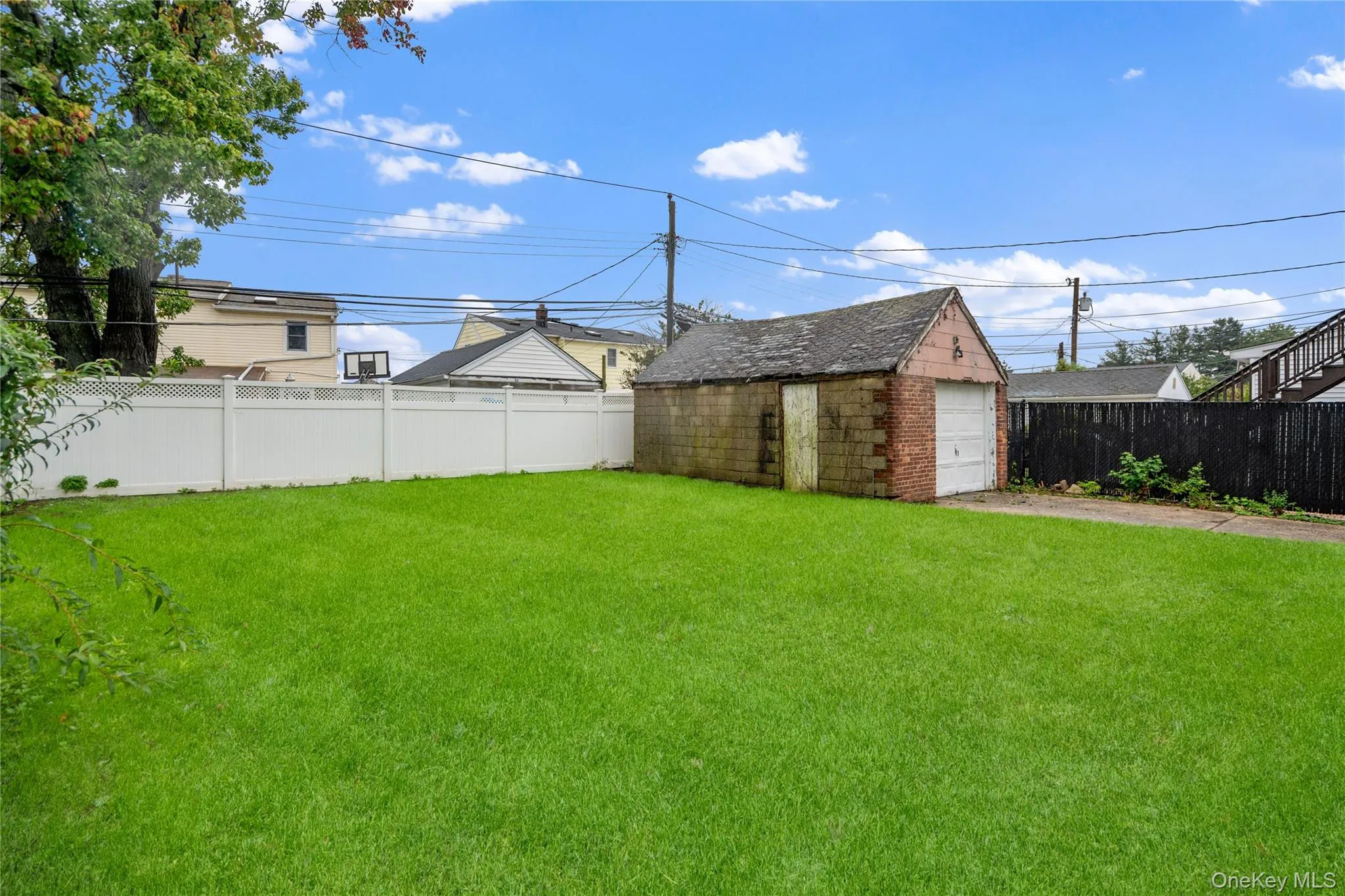 View of the backyard and garage, from the side of the house. View of the backyard and garage, from the side of the house.