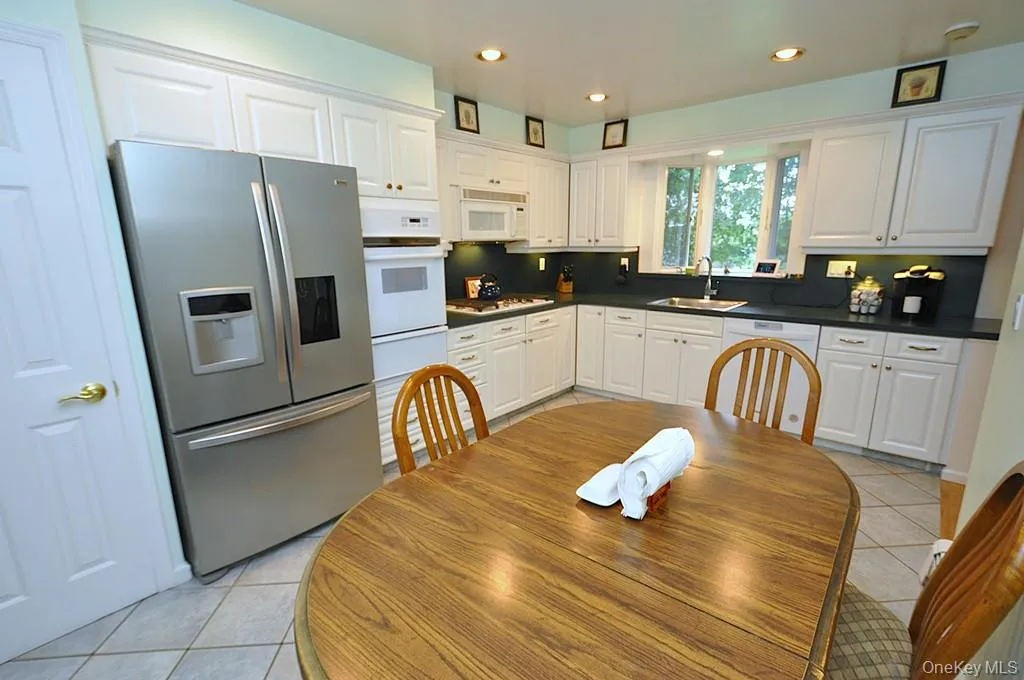 Updated Eat-in-kitchen with granite counters, Stainless Steel French Door refrigerator, wall oven, stove top, and microwave. There is a window over the sink for natural light and ability to watch the backyard. Updated Eat-in-kitchen with granite counters, Stainless Steel French Door refrigerator, wall oven, stove top, and microwave. There is a window over the sink for natural light and ability to watch the backyard.