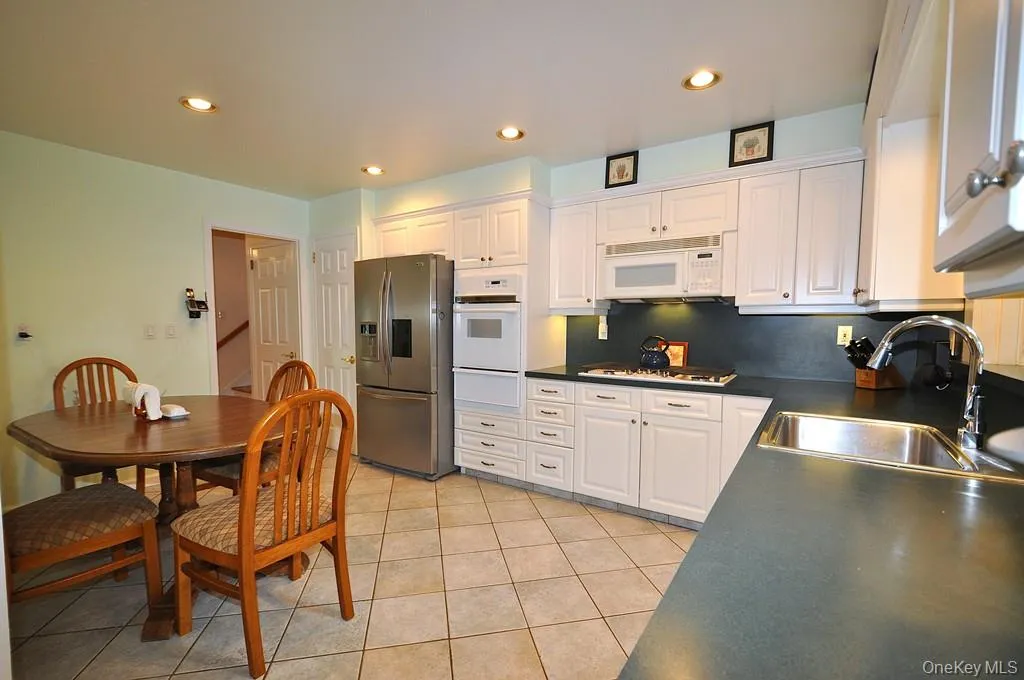 Updated Eat-in-kitchen with granite counters, Stainless Steel French Door refrigerator, wall oven, stove top, and microwave. There is a window over the sink for natural light and ability to watch the backyard. Updated Eat-in-kitchen with granite counters, Stainless Steel French Door refrigerator, wall oven, stove top, and microwave. There is a window over the sink for natural light and ability to watch the backyard.