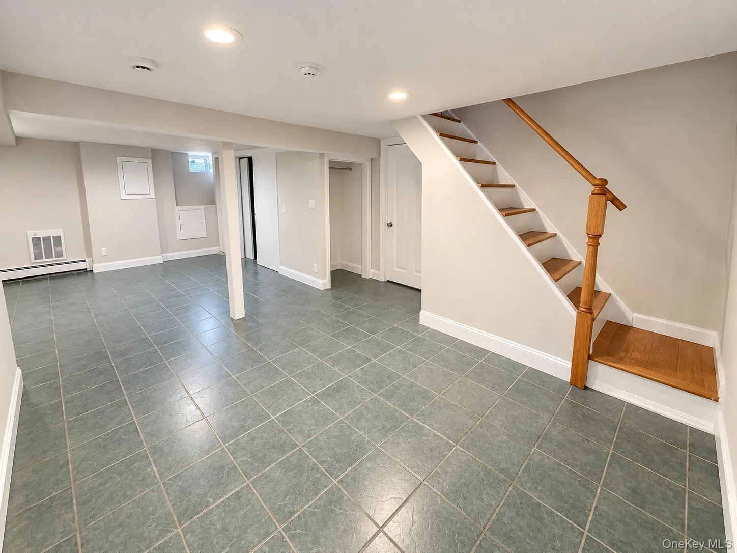 Ceramic tile flooring, white baseboards, recessed lighting, wood staircase with railing, and light-toned walls Ceramic tile flooring, white baseboards, recessed lighting, wood staircase with railing, and light-toned walls