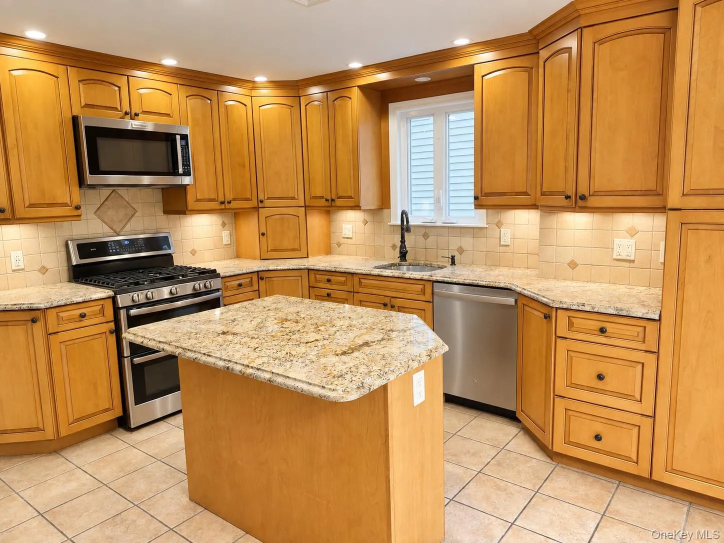 Kitchen featuring wood cabinetry, stone countertops, a tile backsplash, stainless steel appliances, and a central island Kitchen featuring wood cabinetry, stone countertops, a tile backsplash, stainless steel appliances, and a central island