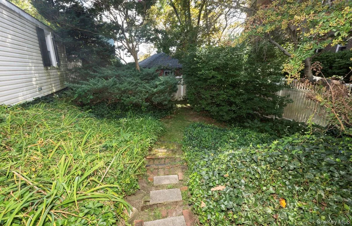Exit from basement leasing around side of home by stone pathway Exit from basement leasing around side of home by stone pathway