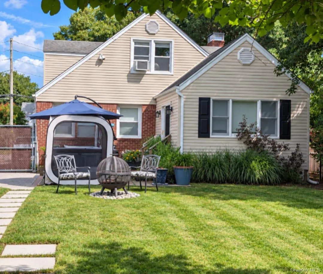 Spacious backyard with patio, grass lawn, and stone paver pathway Spacious backyard with patio, grass lawn, and stone paver pathway