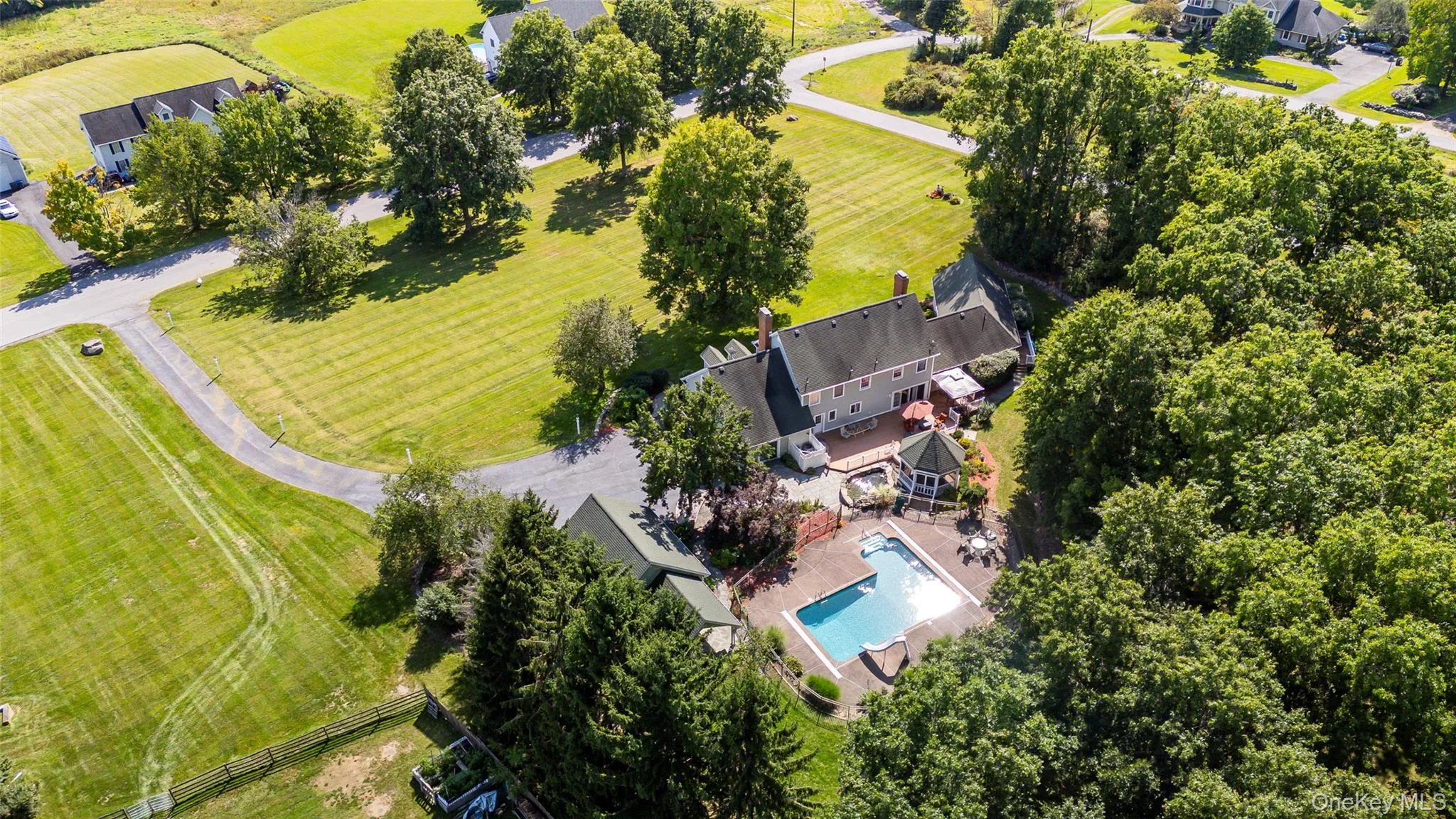 Beautiful corner lot with private inground swimming pool surrounding patio, gazebo, expansive green space, and mature trees Beautiful corner lot with private inground swimming pool surrounding patio, gazebo, expansive green space, and mature trees