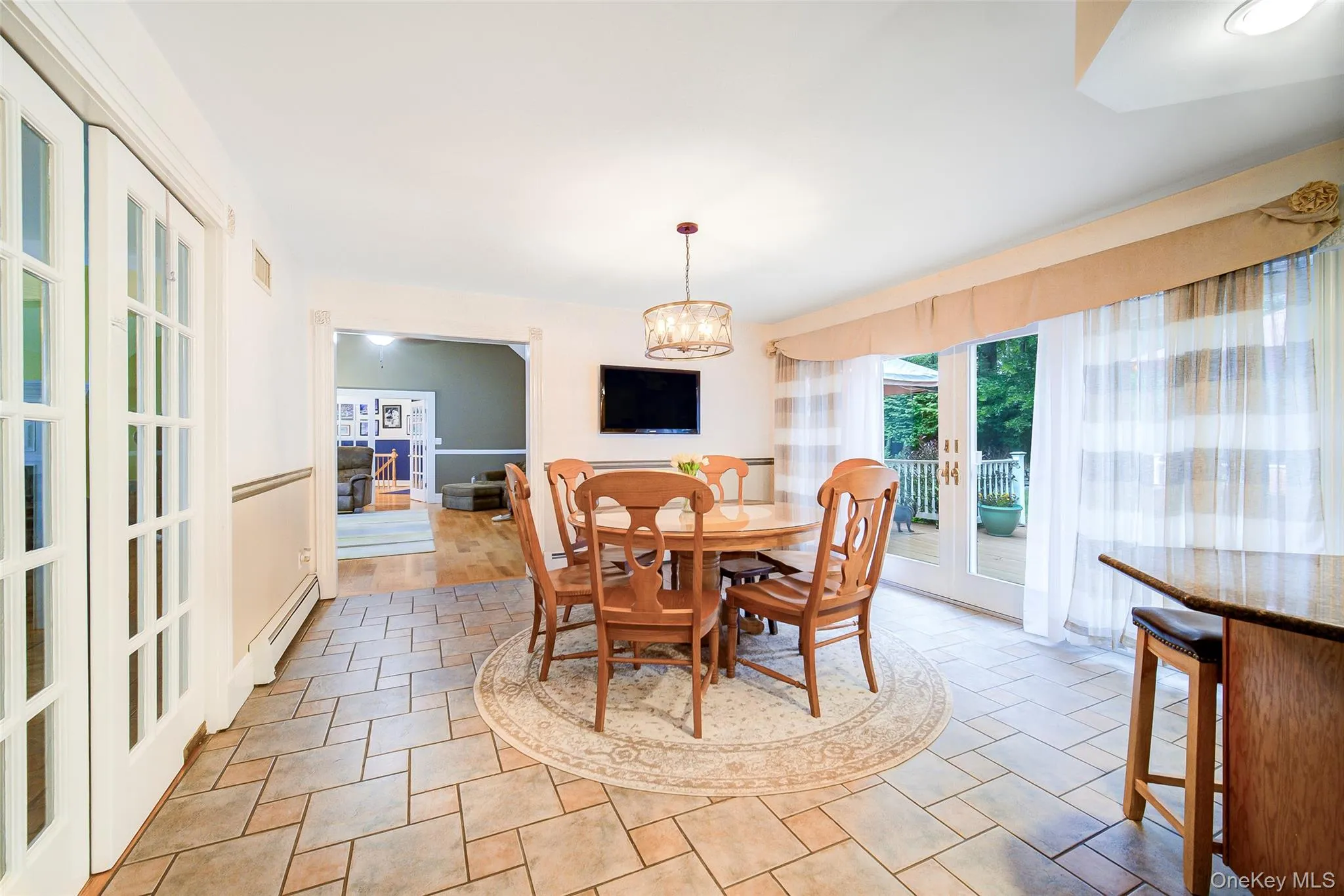 Patterned tile flooring, french doors to dining room, glass patio doors, wood-finish flooring, and a decorative chandelier make this a perfect area for casual dining. Patterned tile flooring, french doors to dining room, glass patio doors, wood-finish flooring, and a decorative chandelier make this a perfect area for casual dining.
