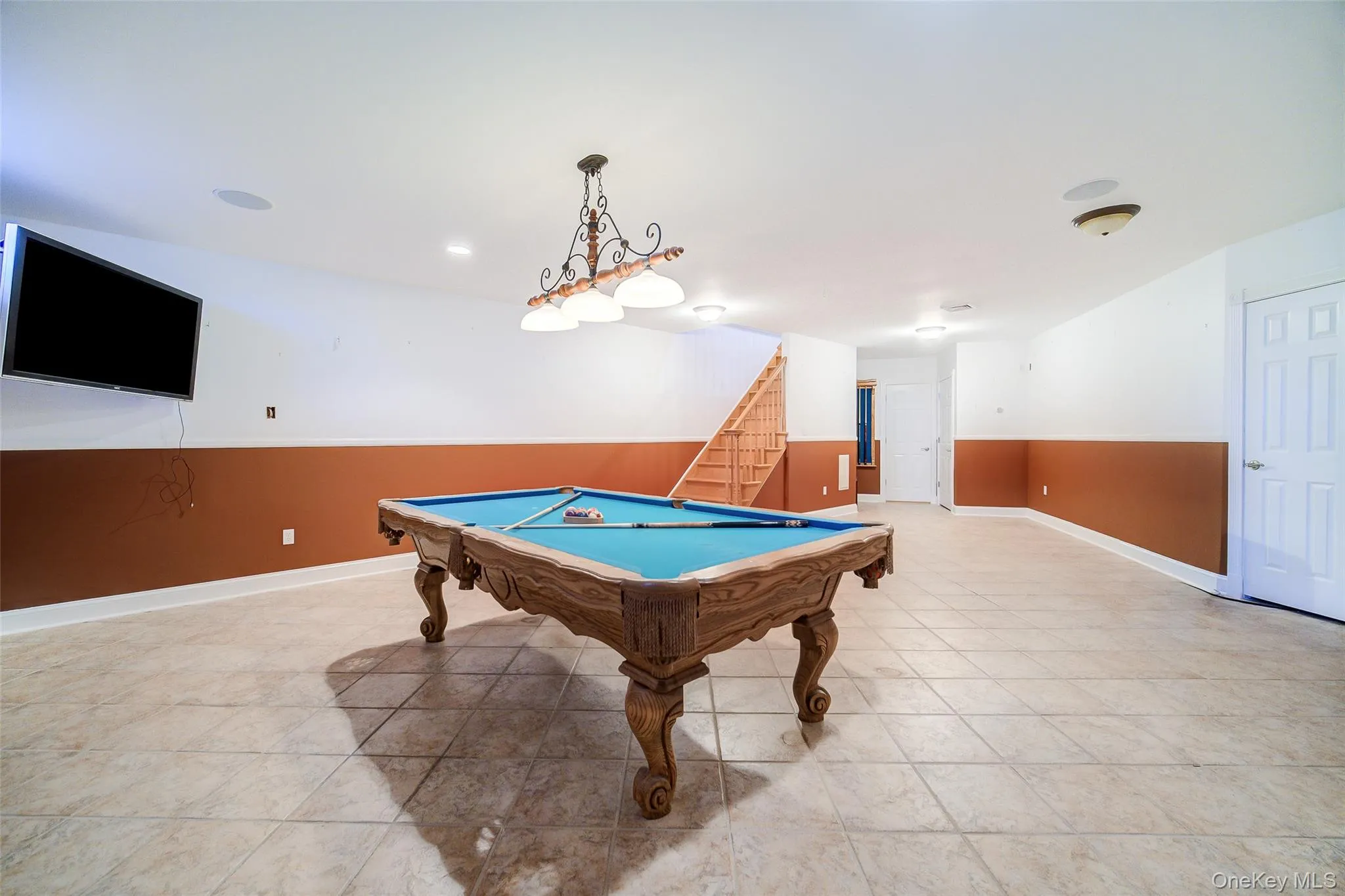 Spacious recreation area featuring tile flooring, recessed lighting, and a built-in sound system Spacious recreation area featuring tile flooring, recessed lighting, and a built-in sound system