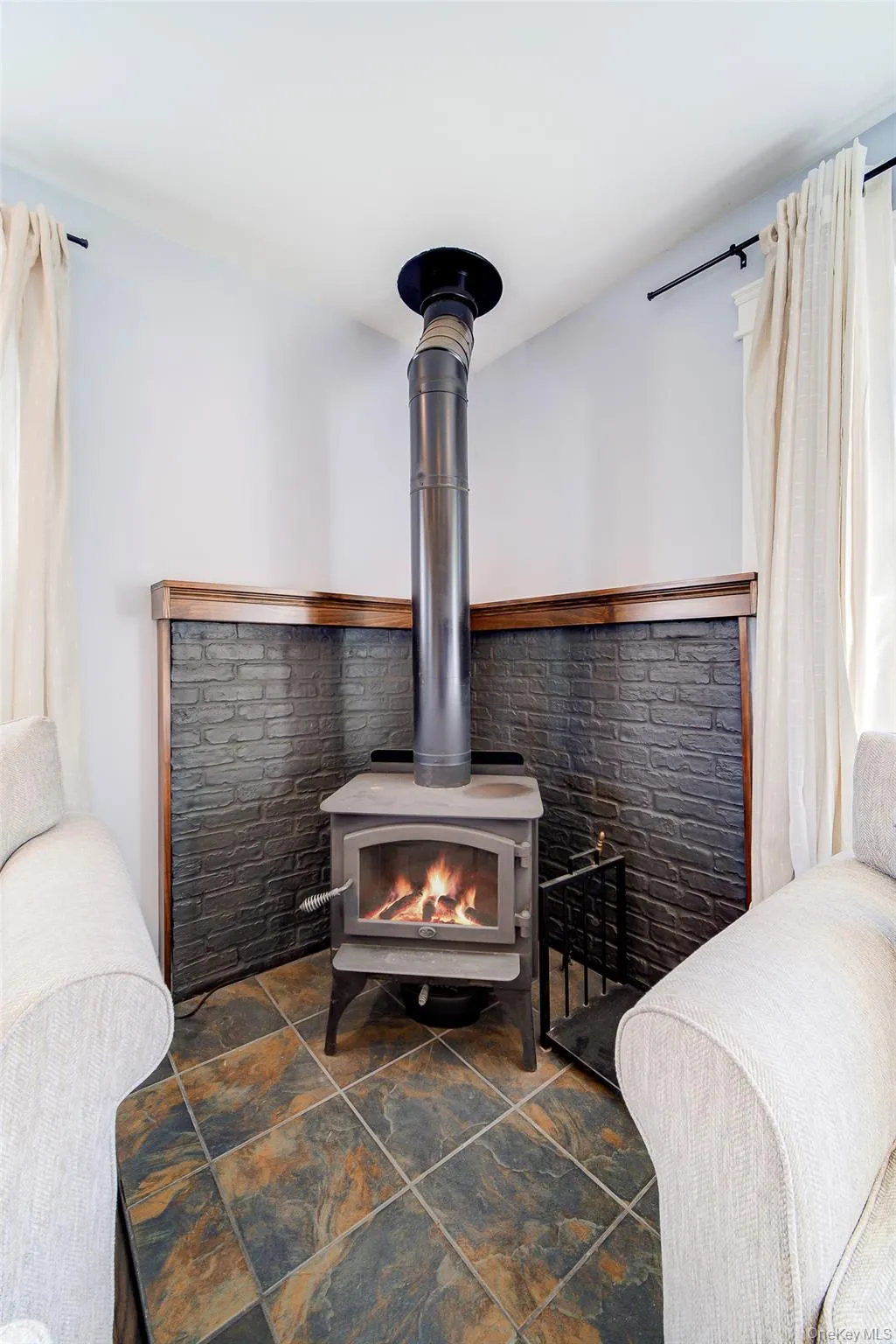 Corner wood-burning stove with a decorative brick surround and wood trim Corner wood-burning stove with a decorative brick surround and wood trim