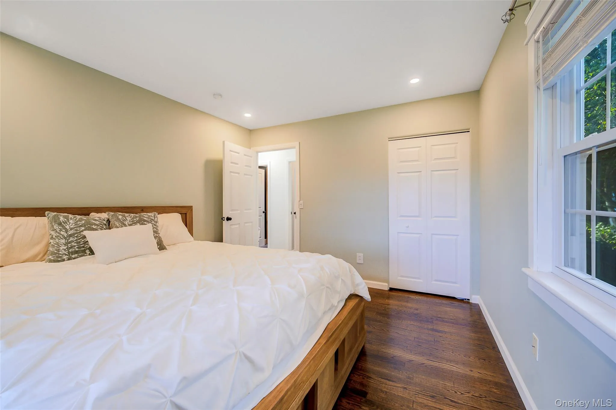 Wood-finish flooring, recessed lighting, double-pane window, and bifold closet doors Wood-finish flooring, recessed lighting, double-pane window, and bifold closet doors