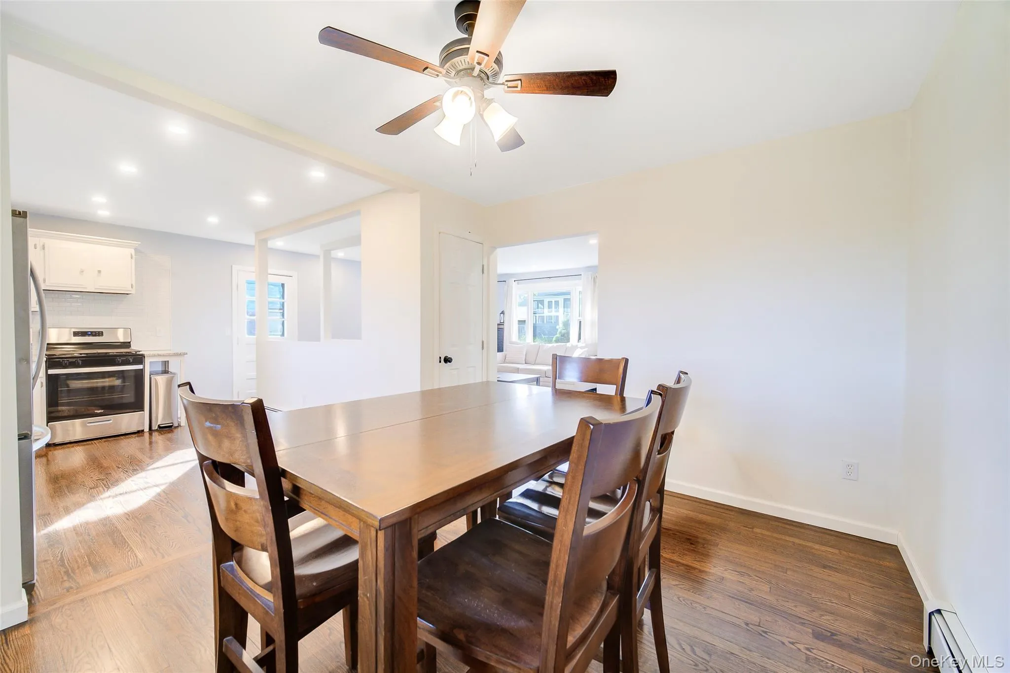 Expansive wood-finish flooring, recessed lighting, and a ceiling fan with light fixture Expansive wood-finish flooring, recessed lighting, and a ceiling fan with light fixture