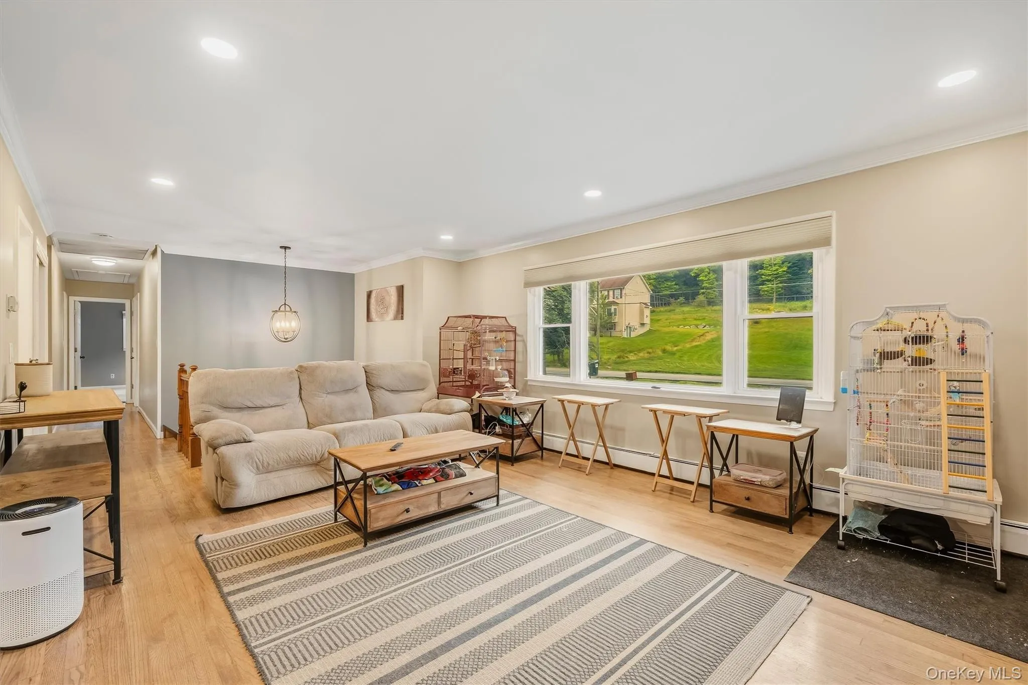 Recessed lighting, crown molding, wood-finish flooring, a decorative pendant light, and a large picture window Recessed lighting, crown molding, wood-finish flooring, a decorative pendant light, and a large picture window