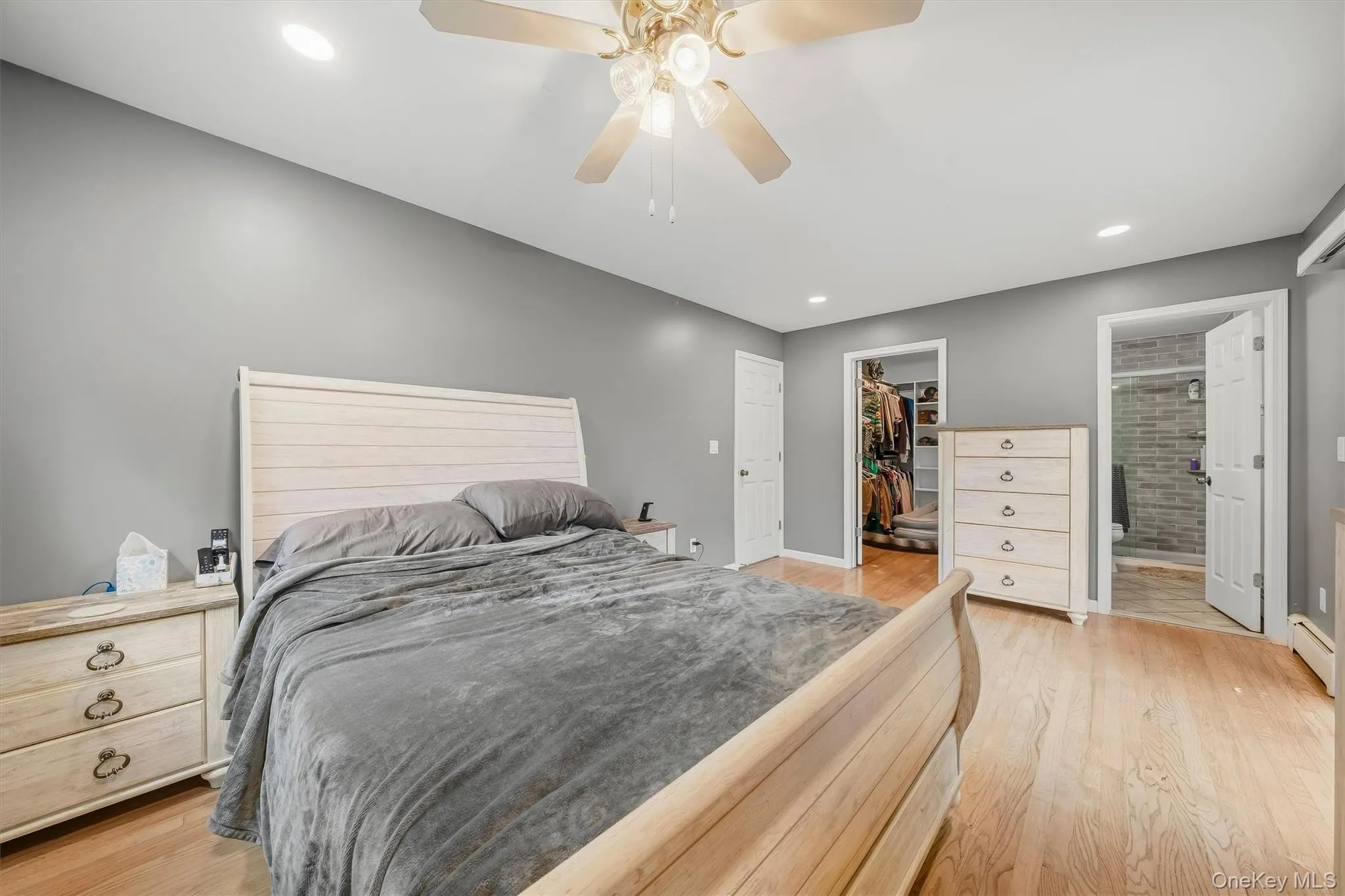 Hardwood flooring, recessed lighting, ceiling fan, walk-in closet, and an attached bathroom with a tiled shower Hardwood flooring, recessed lighting, ceiling fan, walk-in closet, and an attached bathroom with a tiled shower