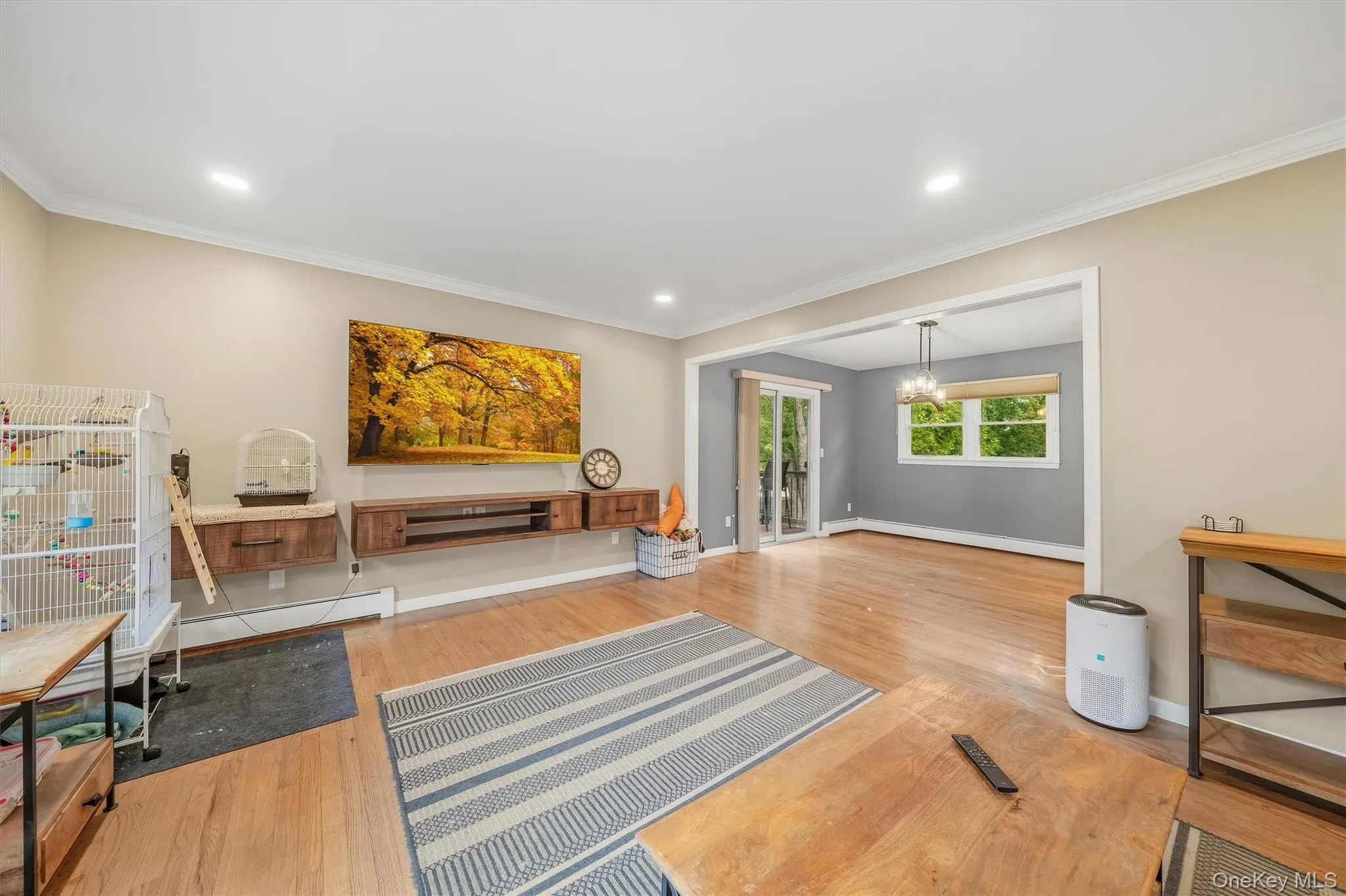 Hardwood flooring, recessed lighting, crown molding, and a built-in entertainment unit with wood-finish shelving Hardwood flooring, recessed lighting, crown molding, and a built-in entertainment unit with wood-finish shelving