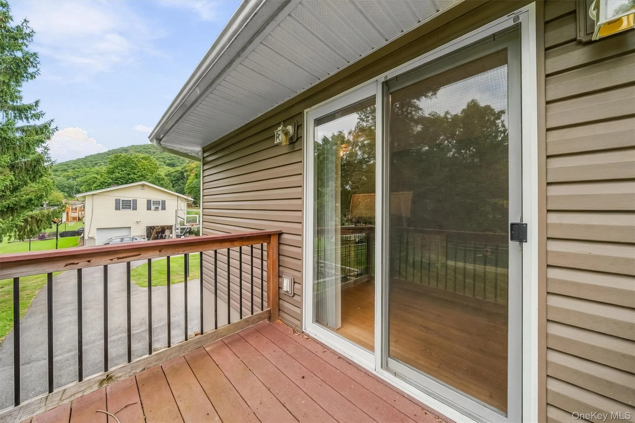 Exterior decking with wood railings, sliding glass door, and vinyl siding Exterior decking with wood railings, sliding glass door, and vinyl siding