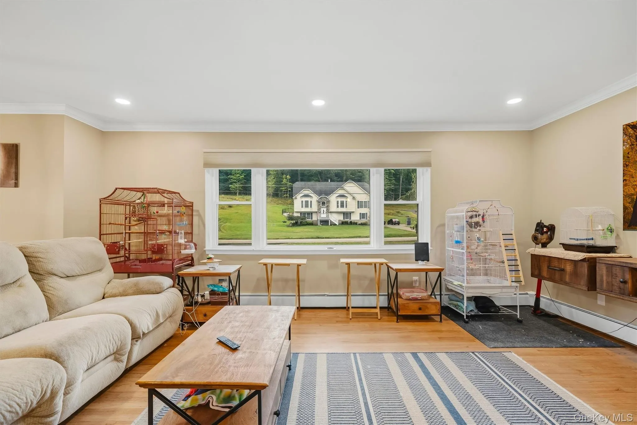 Recessed lighting, crown molding, wood-finish flooring, a large picture window, and a built-in wall console Recessed lighting, crown molding, wood-finish flooring, a large picture window, and a built-in wall console