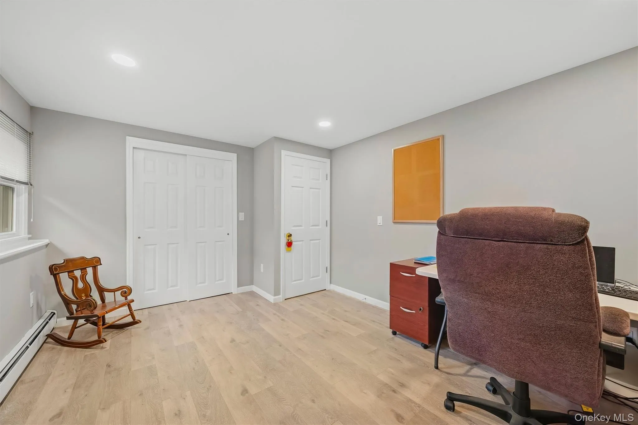 Recessed lighting, wood-finish flooring, two panel doors, window with roller shade, and light gray wall paint Recessed lighting, wood-finish flooring, two panel doors, window with roller shade, and light gray wall paint