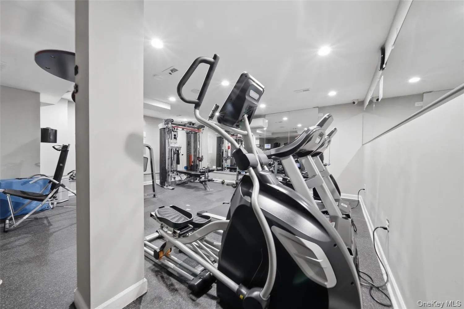Dedicated fitness area featuring recessed lighting, wall-mounted mirrors, and durable rubber flooring Dedicated fitness area featuring recessed lighting, wall-mounted mirrors, and durable rubber flooring