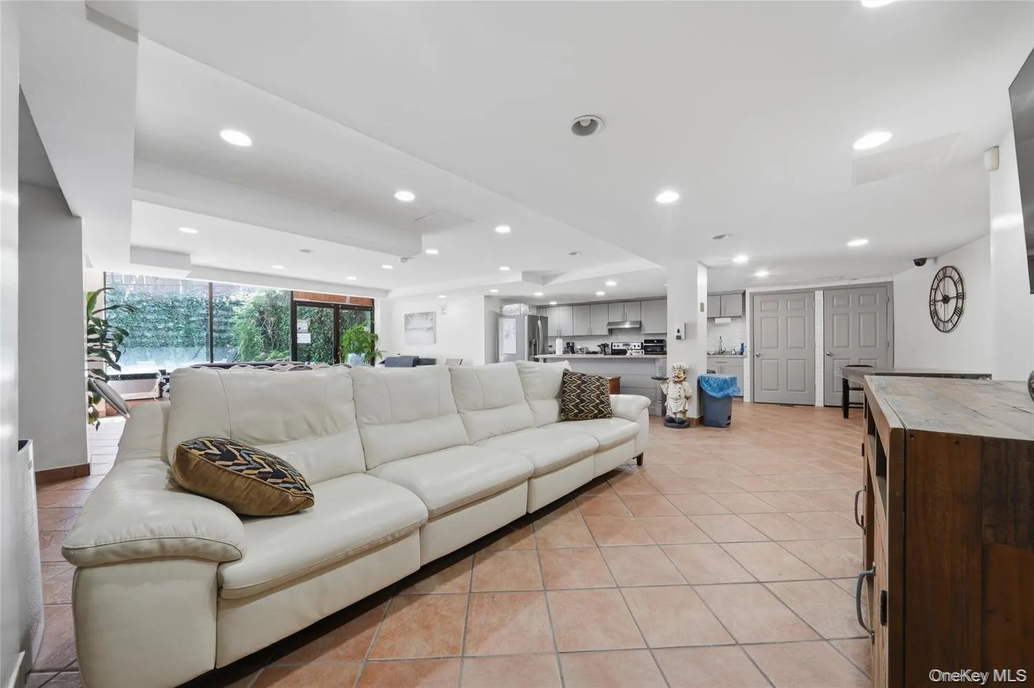 Spacious open-concept community room featuring tile flooring, recessed lighting, and a full wall of glass doors Spacious open-concept community room featuring tile flooring, recessed lighting, and a full wall of glass doors