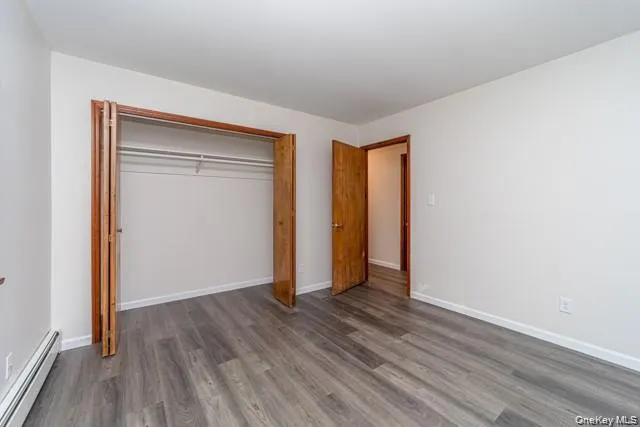 Wood-finish flooring, white painted walls, natural wood-tone doors, and a built-in closet with bi-fold doors Wood-finish flooring, white painted walls, natural wood-tone doors, and a built-in closet with bi-fold doors
