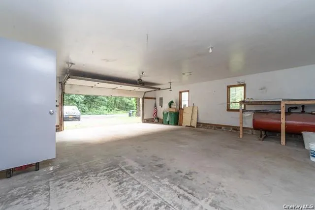 Spacious garage featuring concrete flooring and exposed ceiling beams Spacious garage featuring concrete flooring and exposed ceiling beams