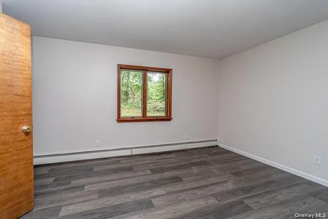 Wood-finish flooring, white walls, and a wood-framed window Wood-finish flooring, white walls, and a wood-framed window