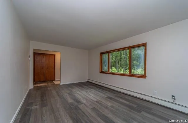 Wood-finish flooring, white walls, wood-framed window, and a wood-paneled double door Wood-finish flooring, white walls, wood-framed window, and a wood-paneled double door