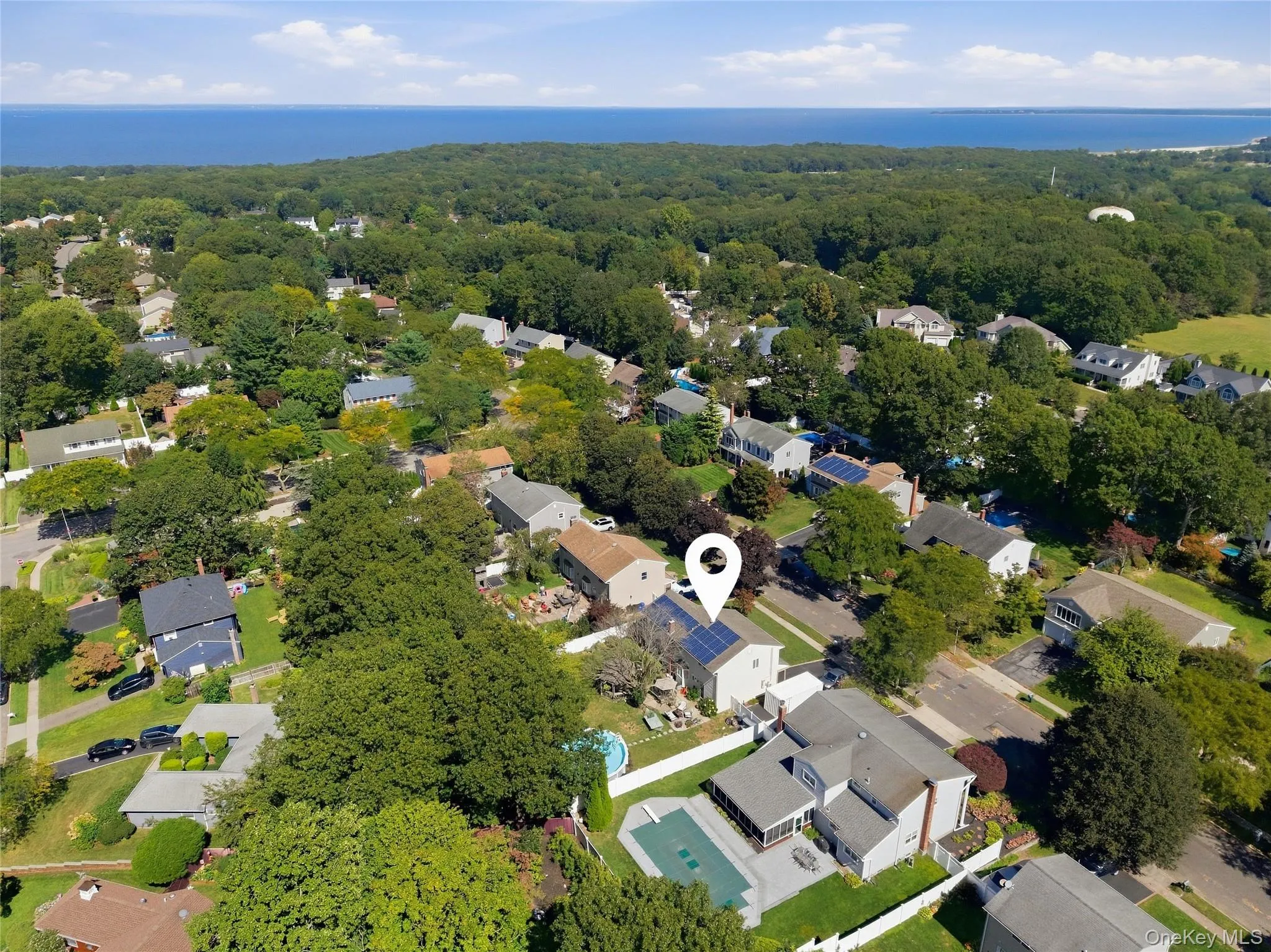 Aerial perspective of a residential community with mature trees and views of the Long Island Sound Aerial perspective of a residential community with mature trees and views of the Long Island Sound