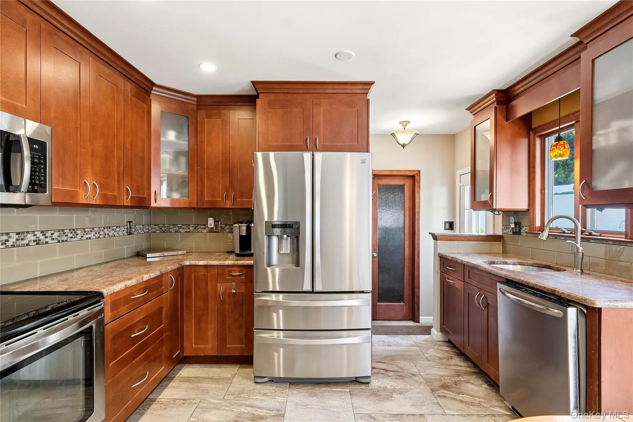 This eat in kitchen has gorgeous hardwood cabinetry, stainless steel refrigerator, tiled flooring, bay window, and recessed lighting This eat in kitchen has gorgeous hardwood cabinetry, stainless steel refrigerator, tiled flooring, bay window, and recessed lighting