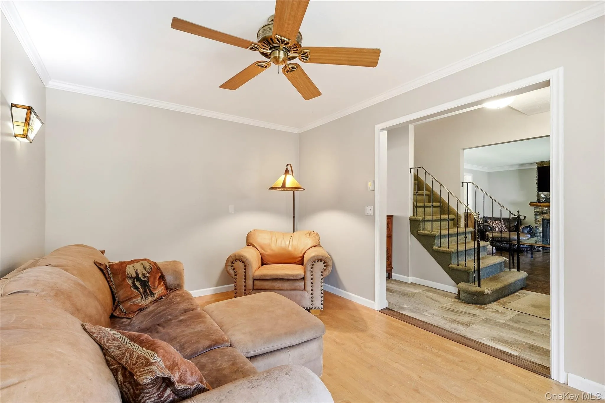 hardwood flooring, crown molding, and an open doorway leading to a staircase with iron railings. This room could also become the dining room. hardwood flooring, crown molding, and an open doorway leading to a staircase with iron railings. This room could also become the dining room.
