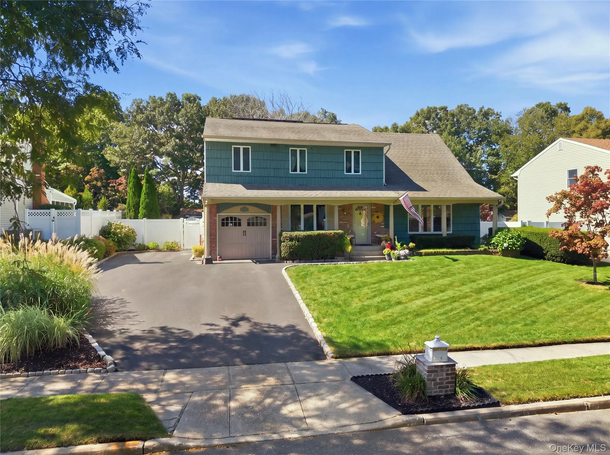 Curb view of home with one car garage, oversized driveway, brick and shingle with covered porch. Curb view of home with one car garage, oversized driveway, brick and shingle with covered porch.