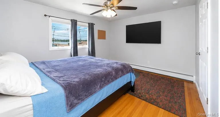 Wood-finish flooring, ceiling fan, and wall-mounted television Wood-finish flooring, ceiling fan, and wall-mounted television