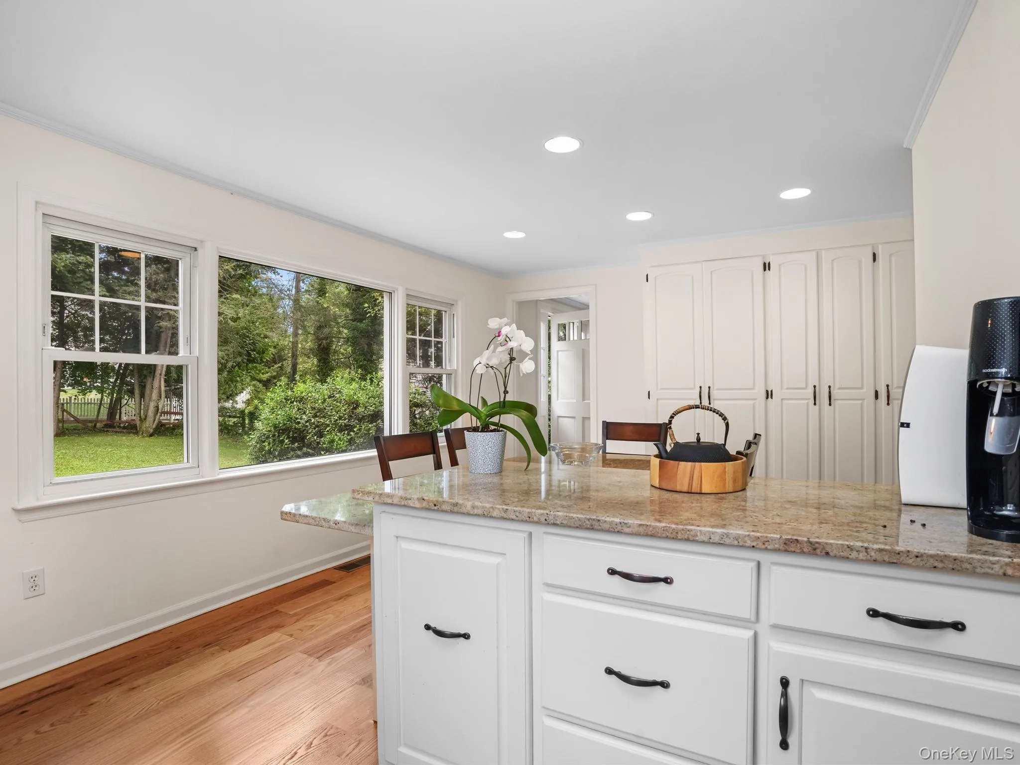 Kitchen featuring white cabinets, light stone counters, recessed lighting, and light wood-style flooring Kitchen featuring white cabinets, light stone counters, recessed lighting, and light wood-style flooring