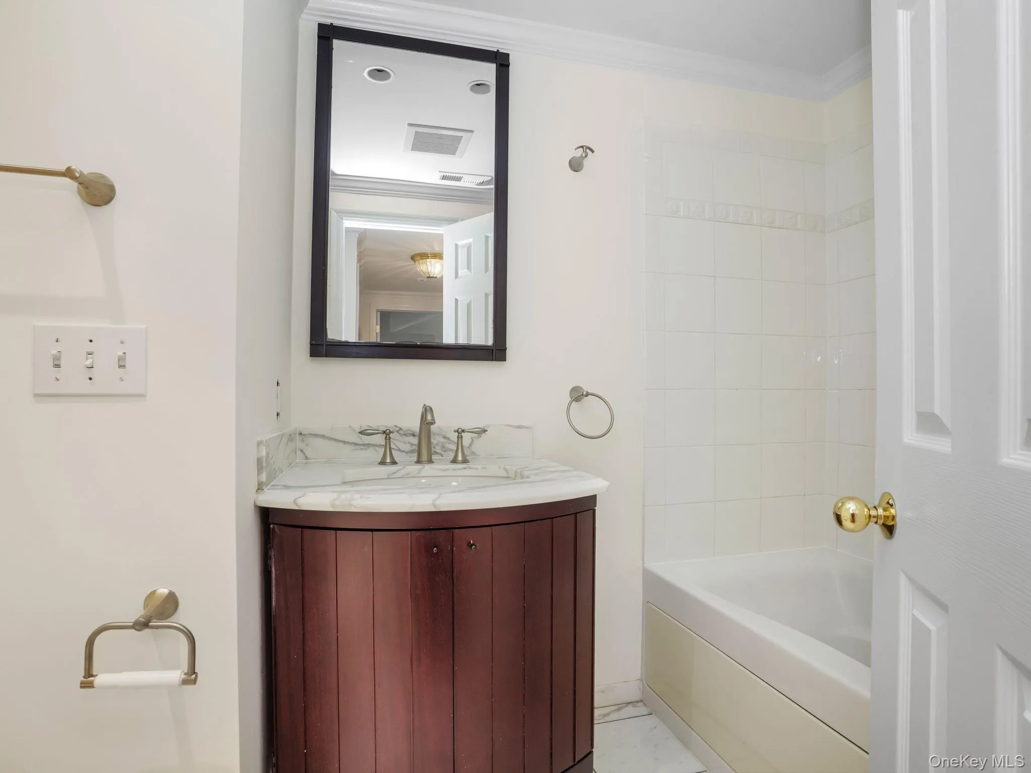 Bathroom with vanity, tub / shower combination, and ornamental molding Bathroom with vanity, tub / shower combination, and ornamental molding