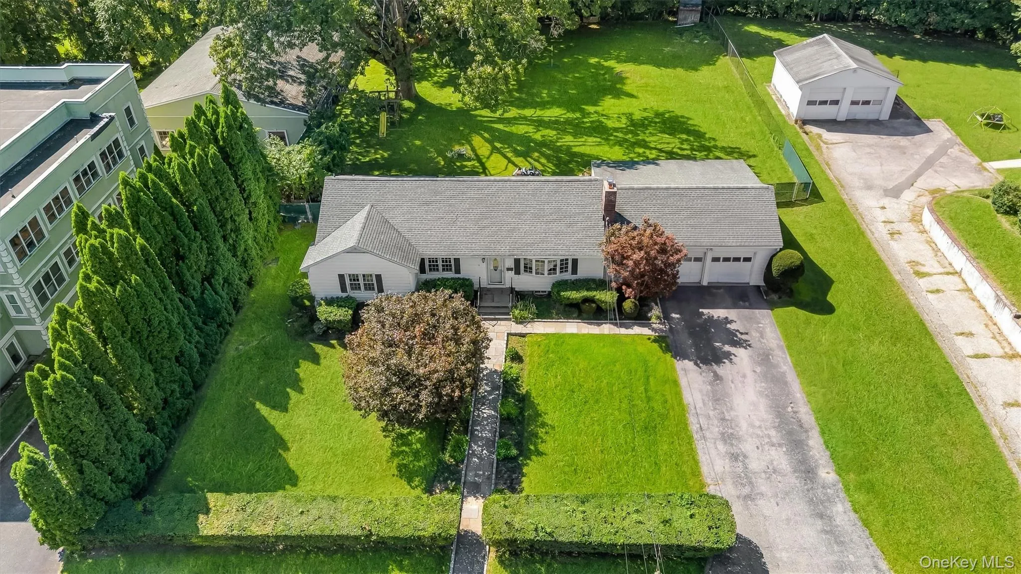 Single-story residence with a two-car garage, mature landscaping, and an additional detached two-car garage Single-story residence with a two-car garage, mature landscaping, and an additional detached two-car garage