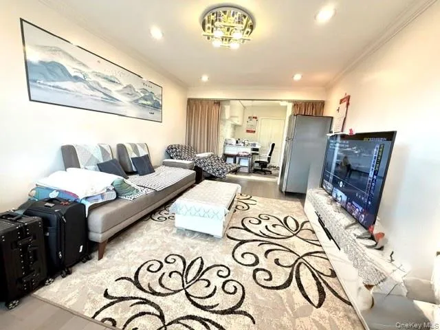 Recessed lighting illuminates a well-defined living area with light-toned walls and wood-finish flooring Recessed lighting illuminates a well-defined living area with light-toned walls and wood-finish flooring