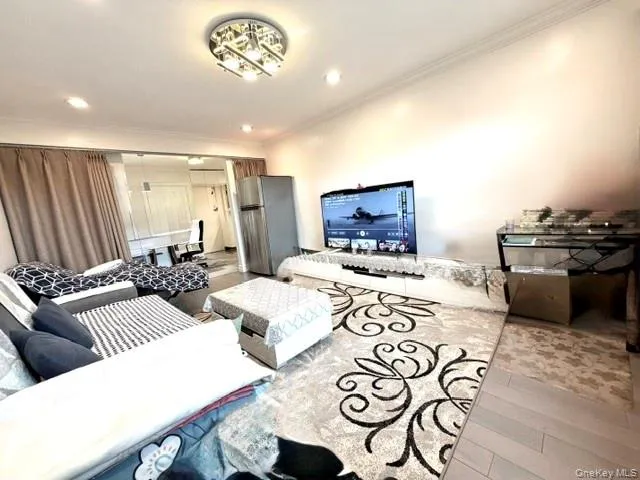 Recessed lighting and a decorative flush mount fixture illuminate this space, featuring light wood-finish flooring Recessed lighting and a decorative flush mount fixture illuminate this space, featuring light wood-finish flooring